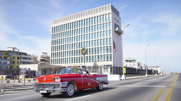 A car drives past the U.S. Embassy in Havana in 2019. Dozens of Americans working at U.S. diplomatic missions in Cuba and China have suffered from ailments that included headaches, balance problems and memory loss in recent years.