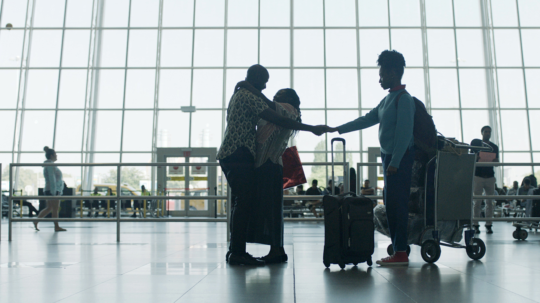 After a 17-year separation, Walter (Ntare Guma Mbaho Mwine) greets his wife Esther (Zainab Jah) and daughter Sylvia (Ekwa Msangi) at JFK airport in the opening scene of Farewell Amor. 