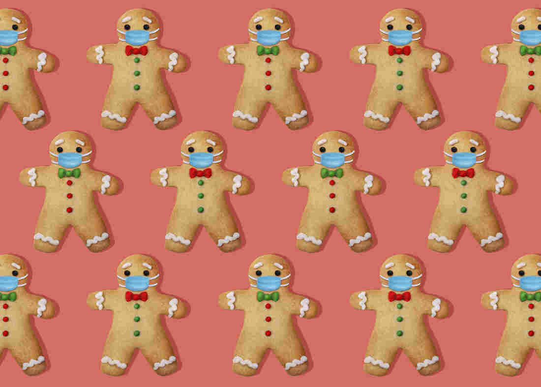 Gingerbread man cookies with surgical mask on pink background.