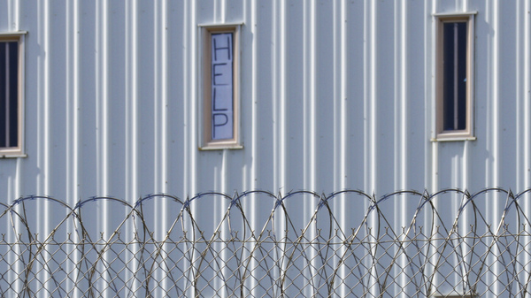 A sign that reads, "HELP," is posted in the window of an inmate cell during a tour with state officials at Holman Correctional Facility in Atmore, Ala., on Oct. 22, 2019. The Justice Department filed a lawsuit this week against Alabama over conditions in its prisons.