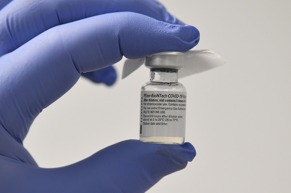 A staff member displays a vial of Pfizer-BioNTech COVID-19 vaccine in Cardiff, Wales on Tuesday.