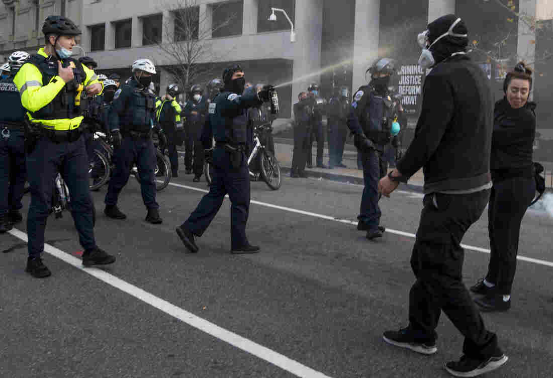 Police spray a counterprotester during a confrontation near Black Lives Matter Plaza.