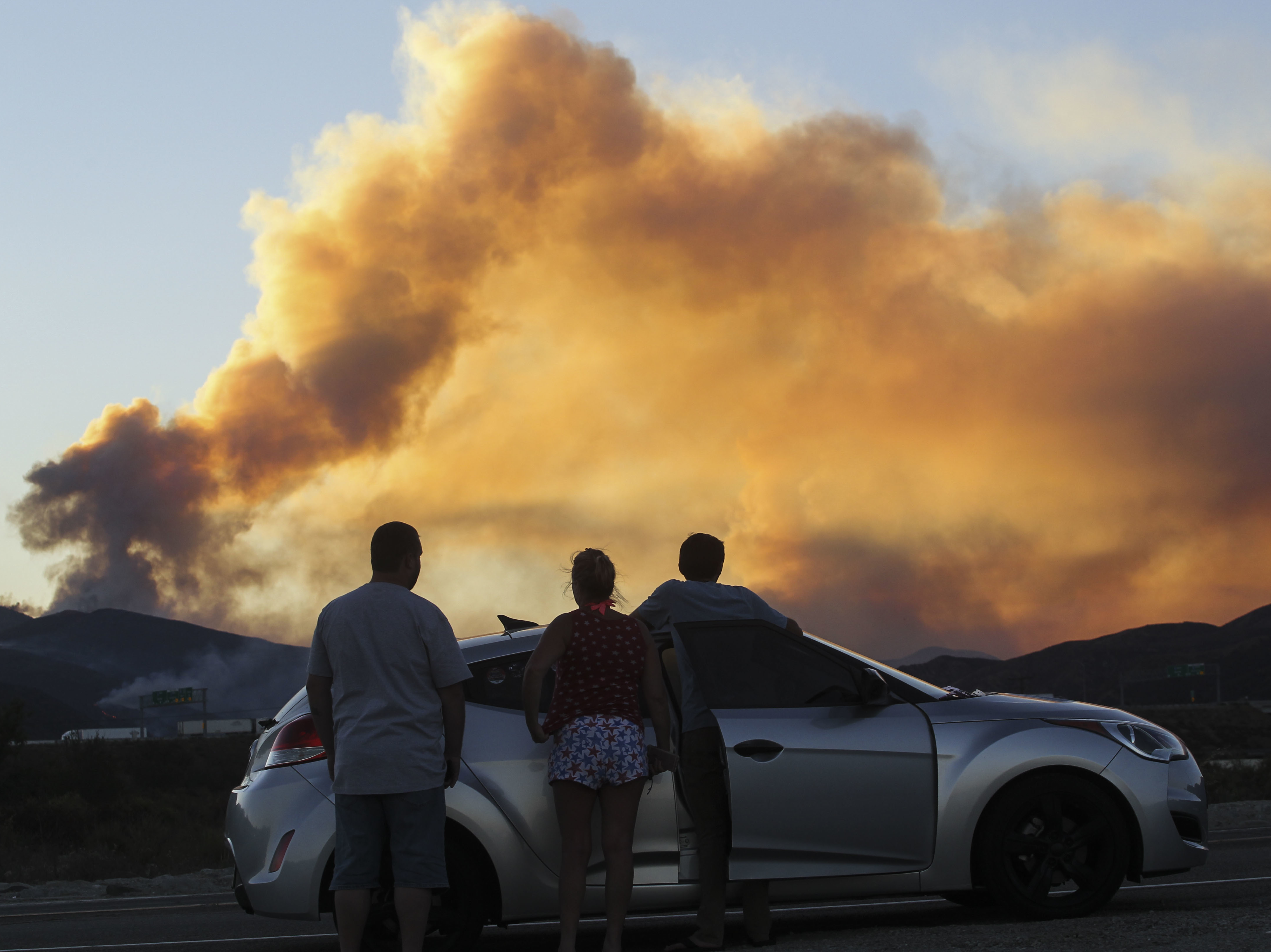 People watch the Blue Cut Fire in Lytle Creek, Calif., in 2016. (AFP via Getty Images)