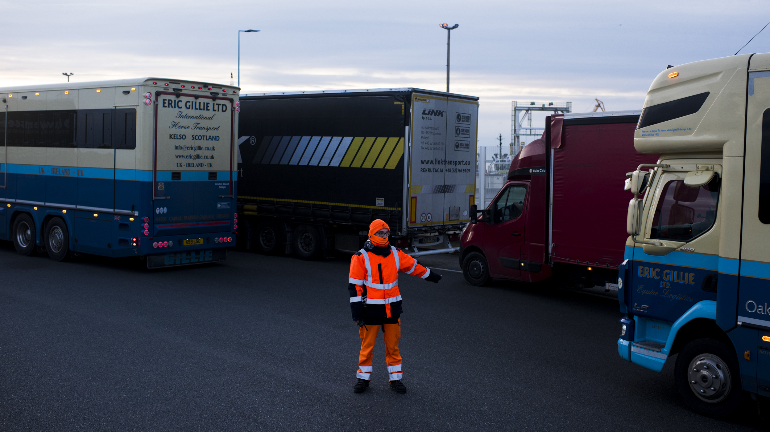 A worker directs trucks where to wait in line in order to board ferries to the United Kingdom in Calais, France. Twenty percent of British imports pass through the port of Calais.