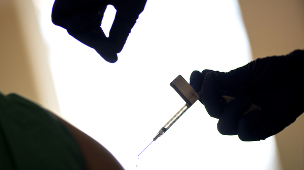 A droplet falls from a syringe after a health care worker was injected with the Pfizer-BioNTech COVID-19 vaccine at Women & Infants Hospital in Providence, R.I.