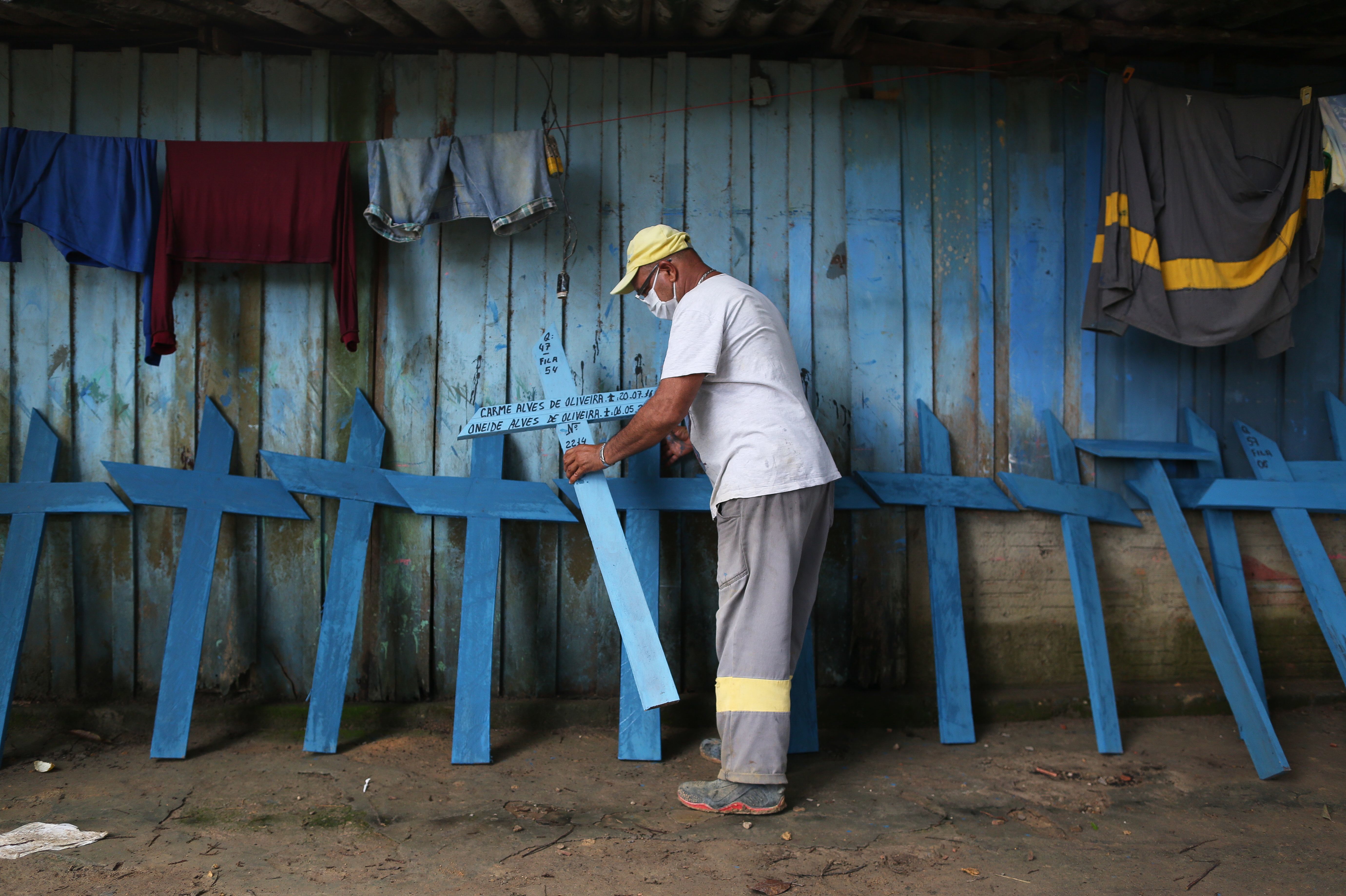 Ulisses Xavier, 52, who has worked for 16 years at Nossa Senhora cemetery in Manaus, Brazil, makes wooden crosses to supplement his income. The cemetery has seen a surge in the number of new graves after the outbreak of COVID-19. (AFP via Getty Images)