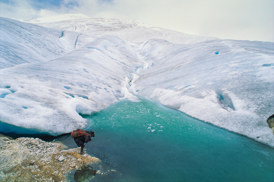 A barefoot porter totes a load for an expedition visiting one of the remaining glaciers near the equator, 16,000 feet high on the highest peak in Papua, Indonesia.