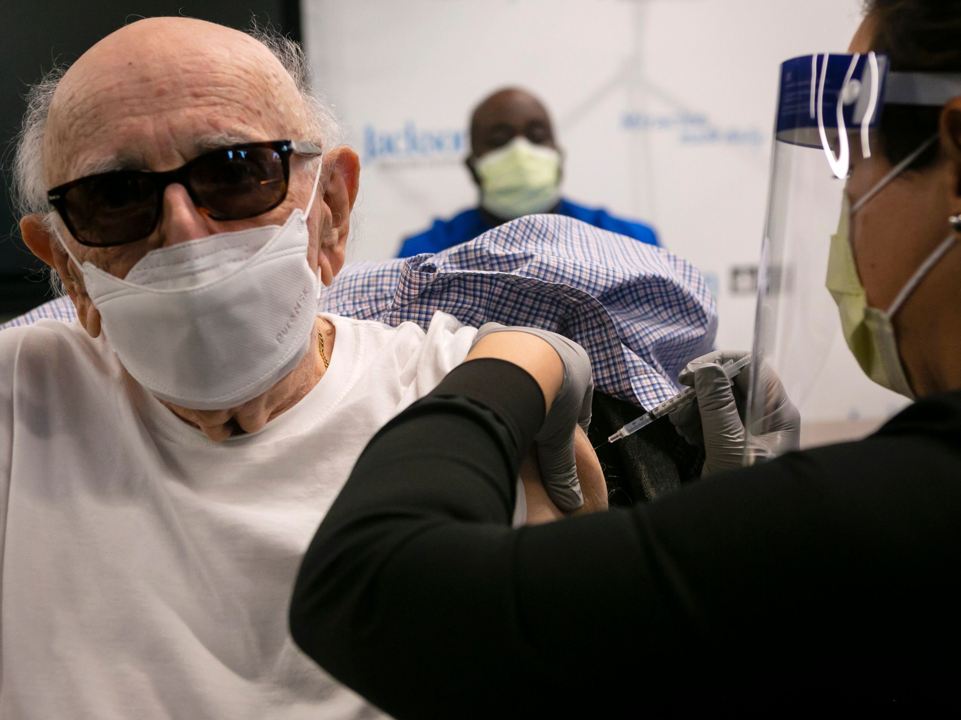 Norman Einspruch, 88, a cardiology patient at Jackson Memorial Hospital in Miami, Fla., receives his first dose of the Pfizer-BioNtech COVID-19 vaccine Dec. 30. (AFP via Getty Images)