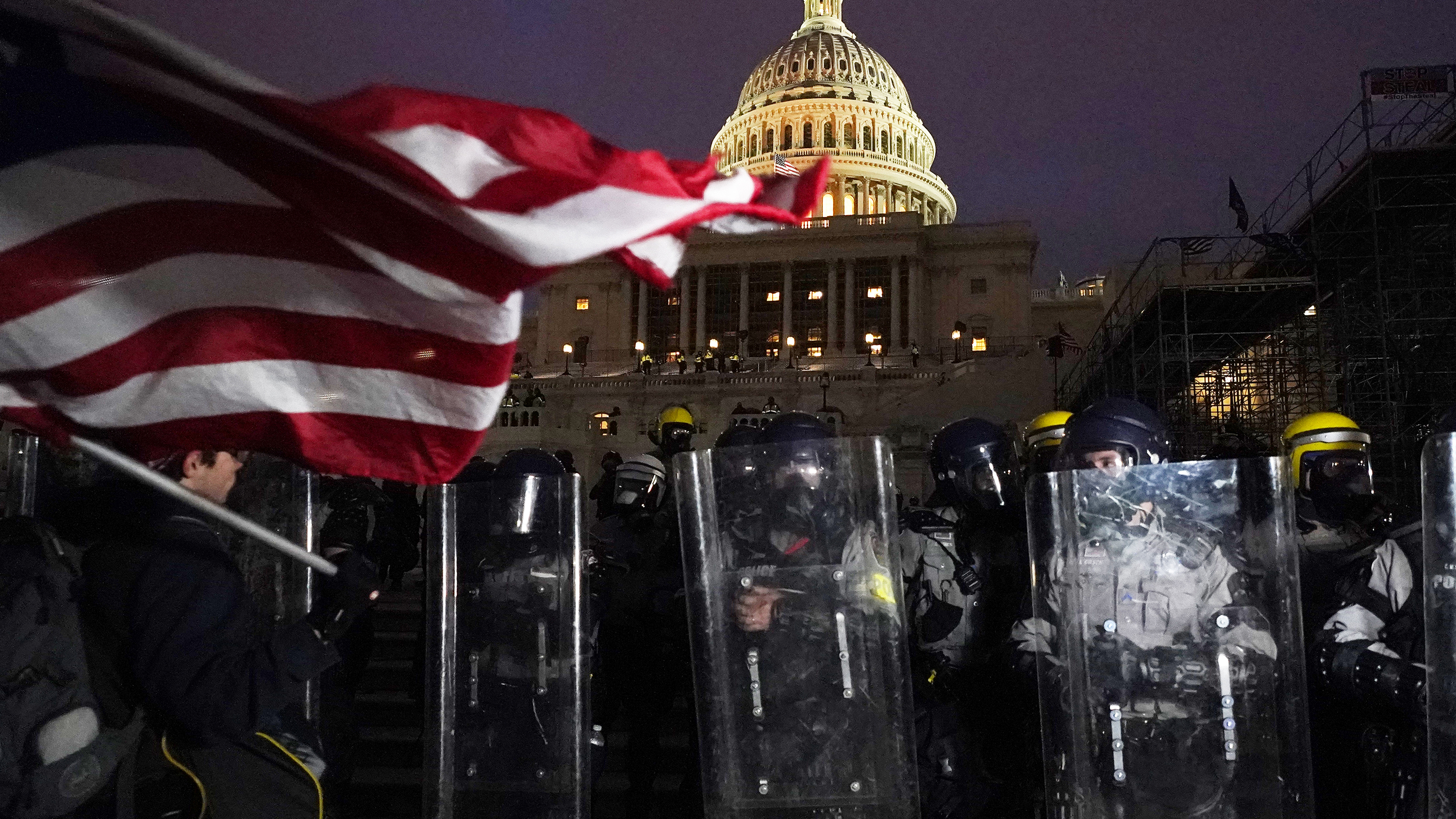 Police stand behind their shields outside the Capitol after a day of rioting on Wednesday.