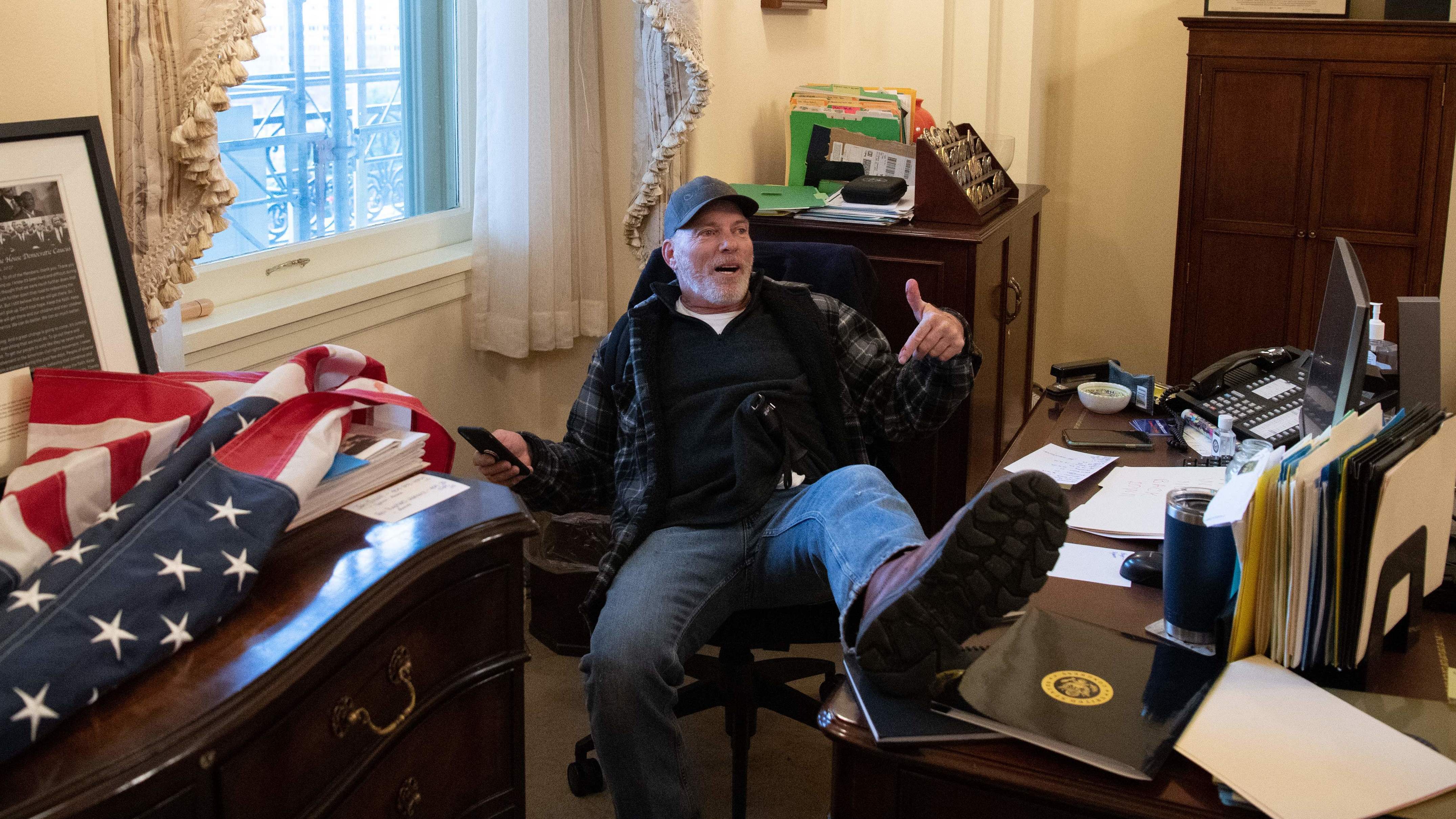 Richard Barnett has been arrested in his home state of Arkansas and faces charges related to his part in the forced entry into the Capitol. During the riot, Barnett sat in House Speaker Nancy Pelosi