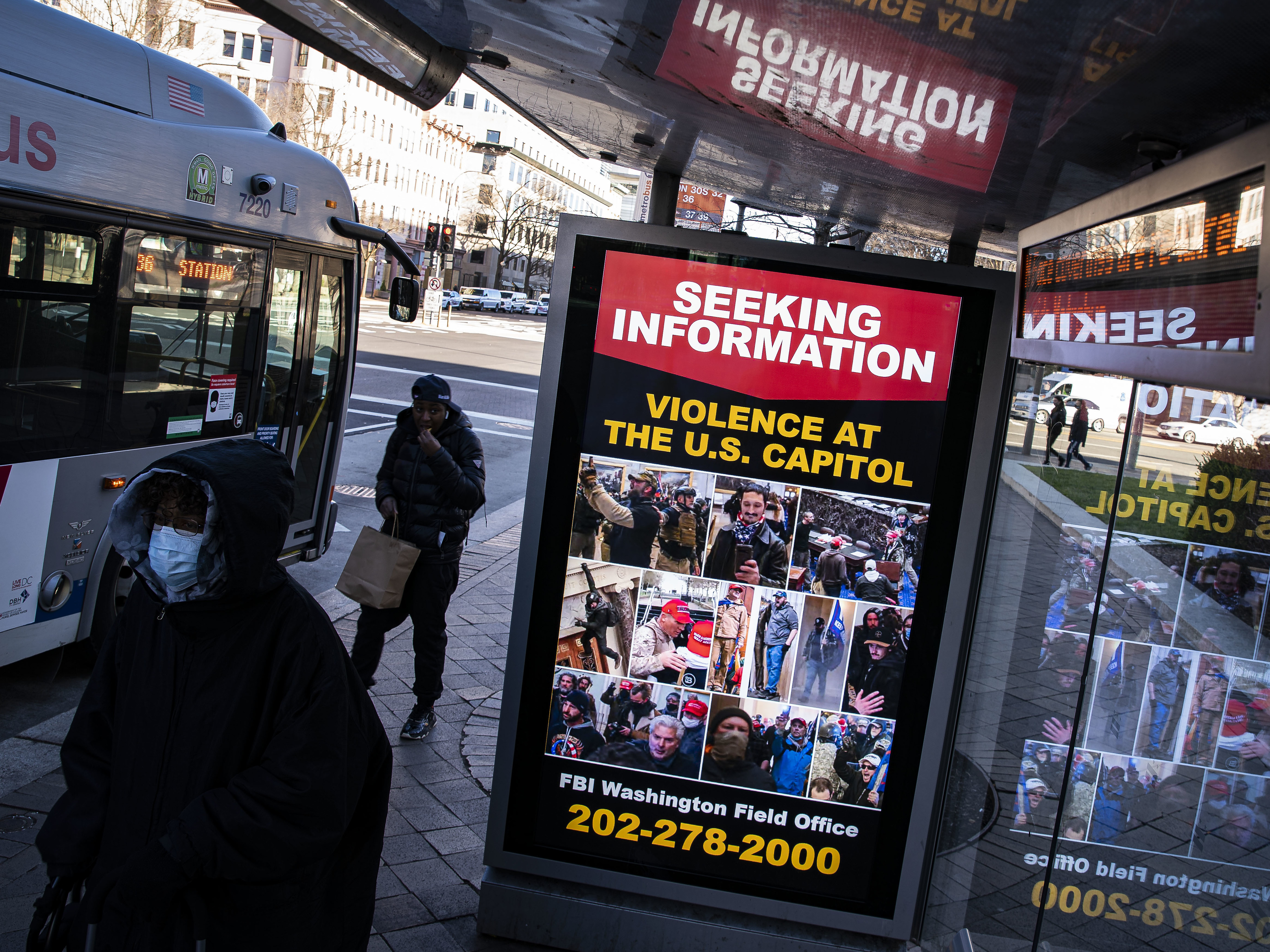At a bus stop on Pennsylvania Avenue Northwest in Washington, D.C., a notice from the FBI seeks information about people pictured during the riot at the U.S. Capitol on Wednesday. (Getty Images)