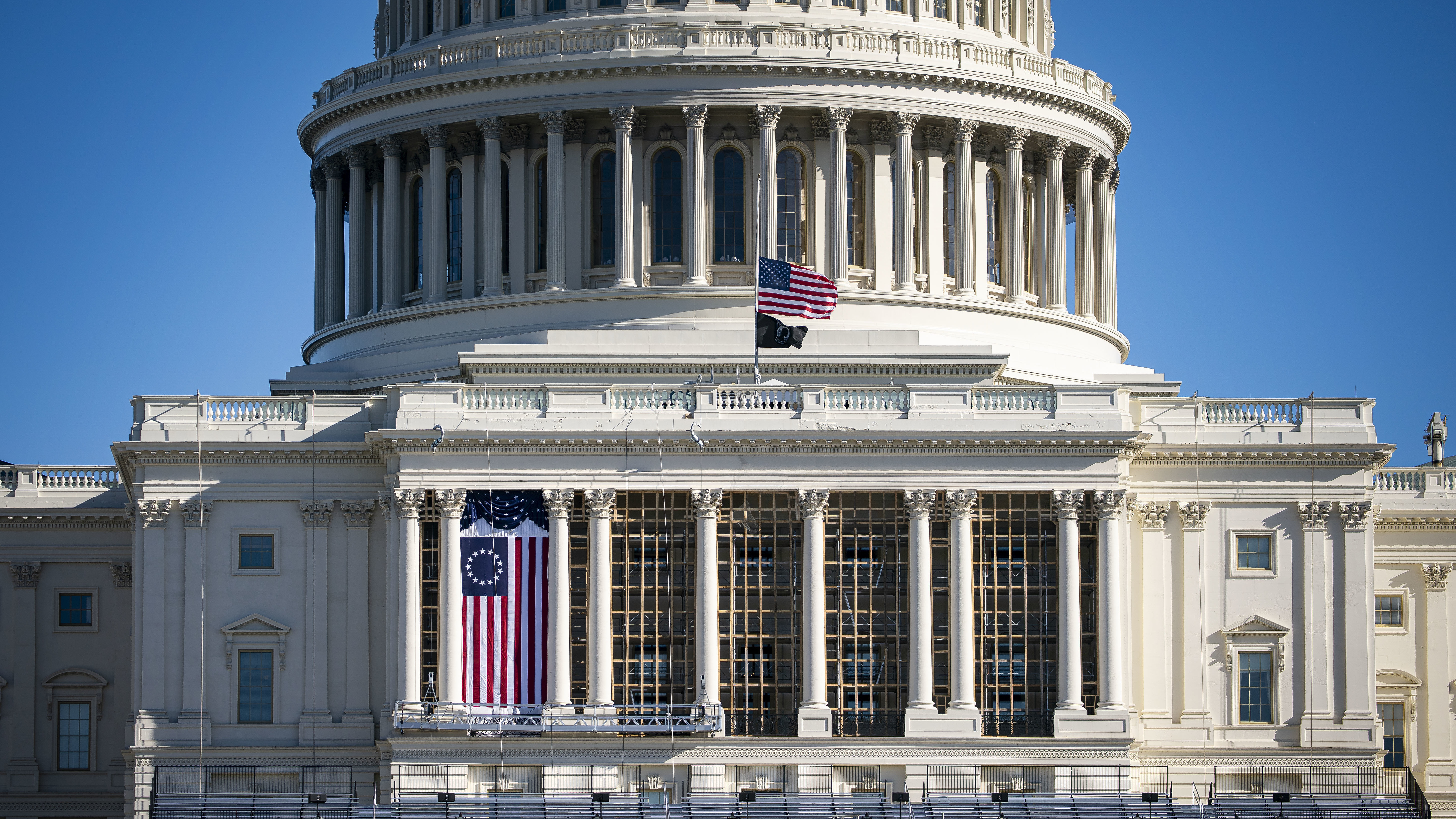 The American flag flies at half-staff on the west front of the U.S. Capitol after the Jan. 6 insurrection.