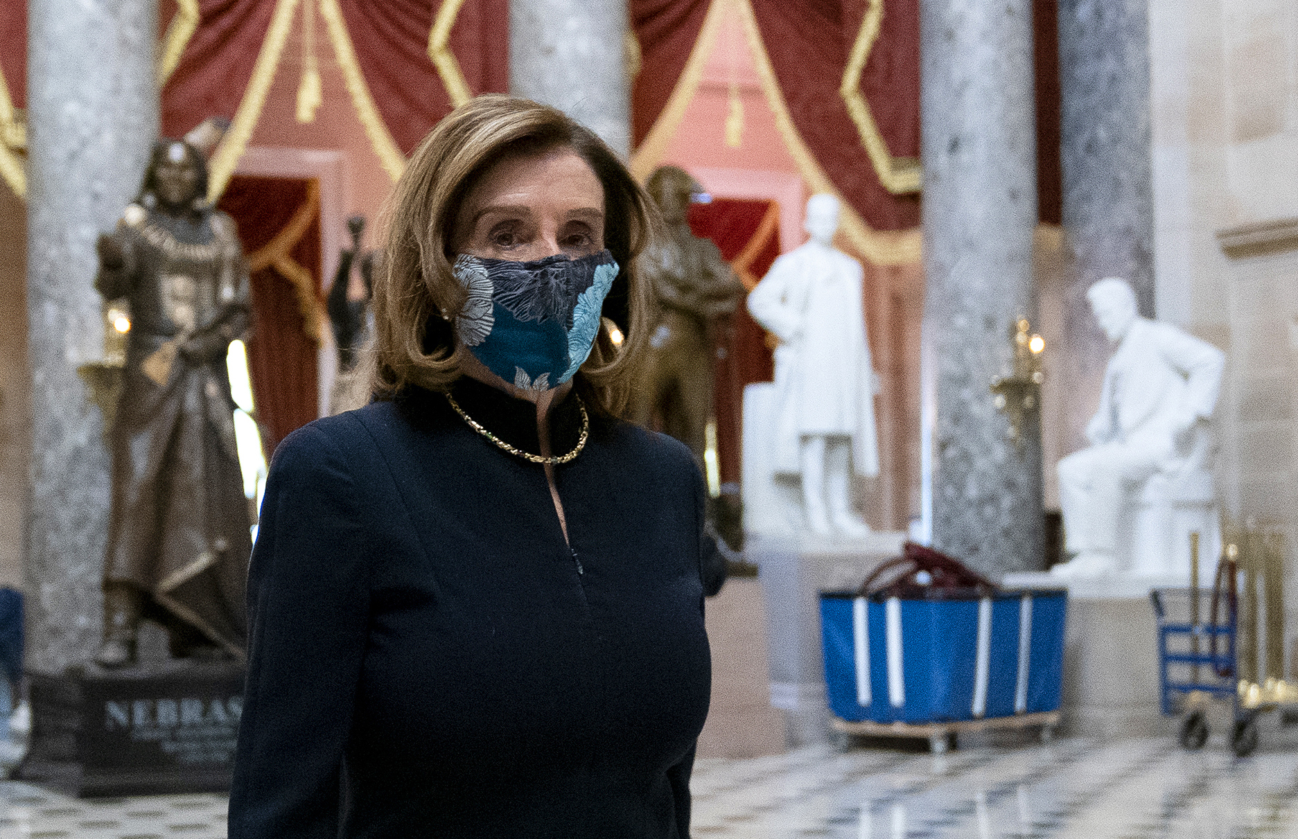 Speaker of the House Nancy Pelosi wears a protective mask while walking to her office from the House Floor on Wednesday. (Getty Images)