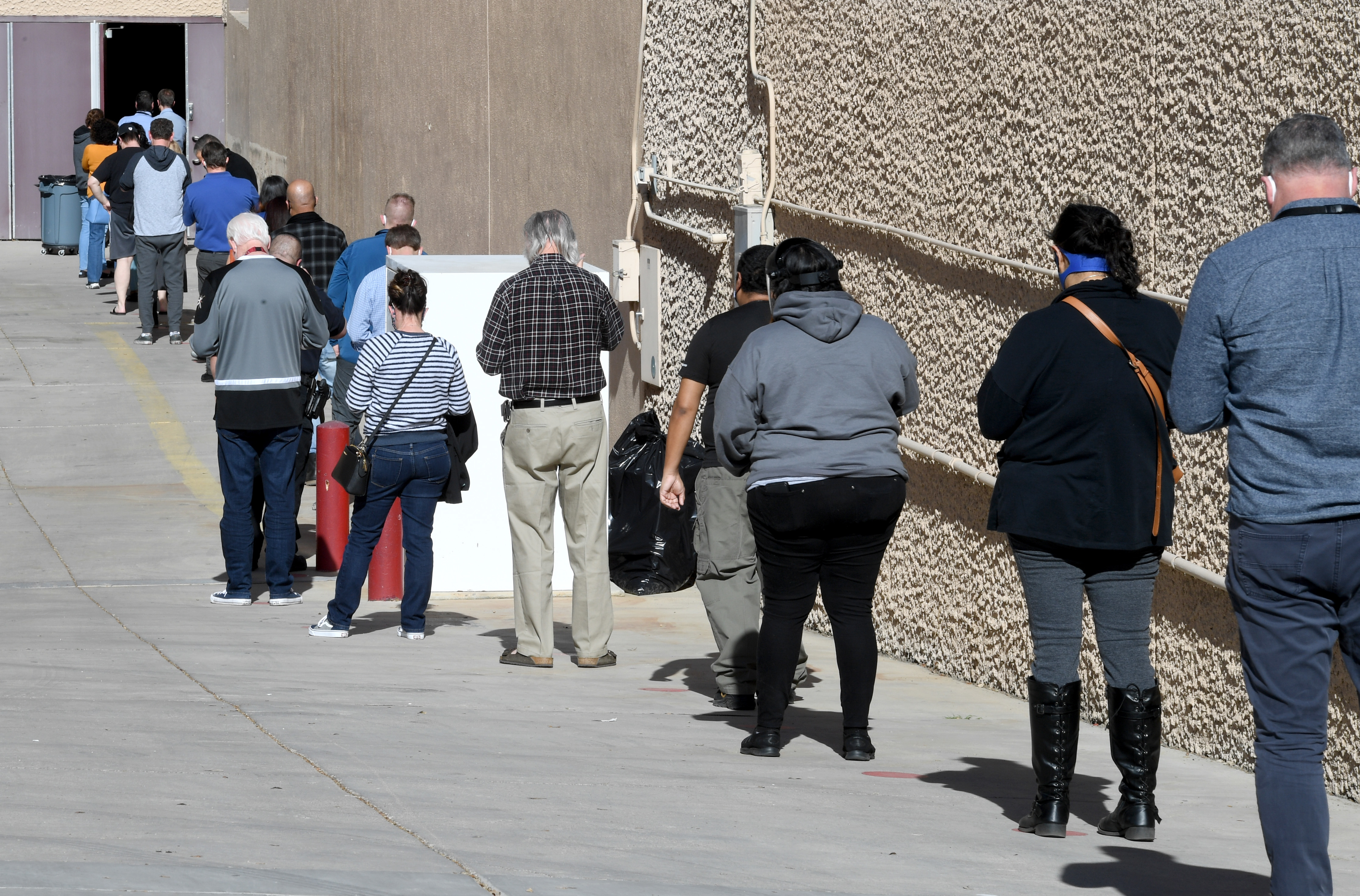 People line up on Thursday for the first day of Clark County's pilot COVID-19 vaccination program at Cashman Center in Las Vegas. (Getty Images)