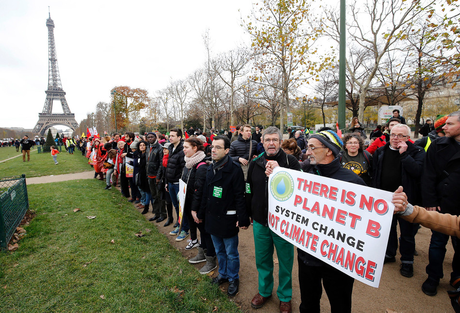 President Joe Biden is directing the U.S. to rejoin the international Paris Climate Agreement, which aims to cut global greenhouse gas emissions. Here, activists rally on Dec. 12, 2015. (Francois Guillot/AFP via Getty Images)