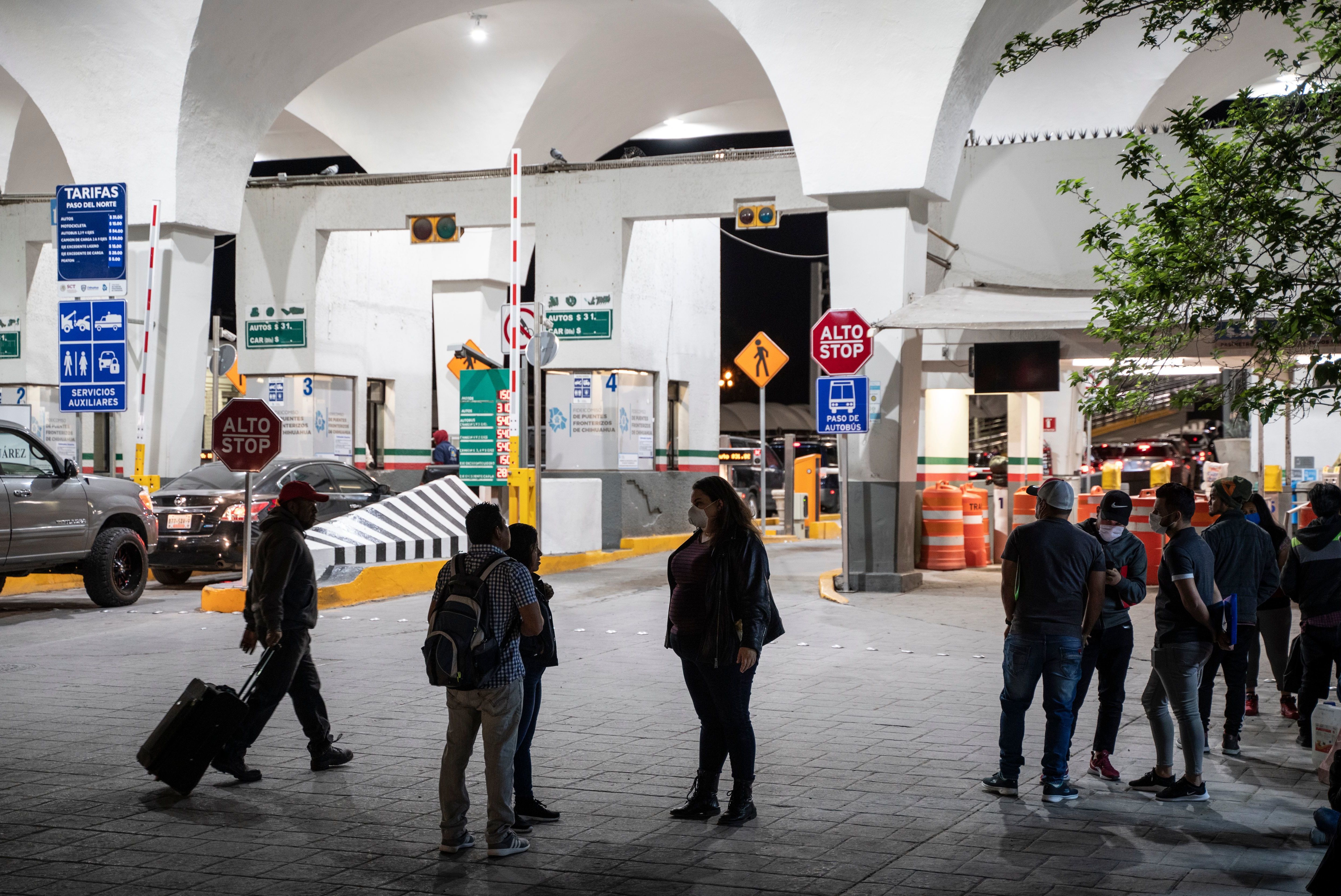 Migrants are greeted by Taylor Levy (center), a local immigration attorney, at the Paso del Norte International Bridge in April 2020 in Ciudad Juarez, Mexico. People seeking asylum were enrolled in the Migrant Protection Protocols program, better known as the &quot;Remain in Mexico&quot; policy. The Department of Homeland Security announced that starting Thursday, it would stop new enrollments in MPP. (AFP via Getty Images)