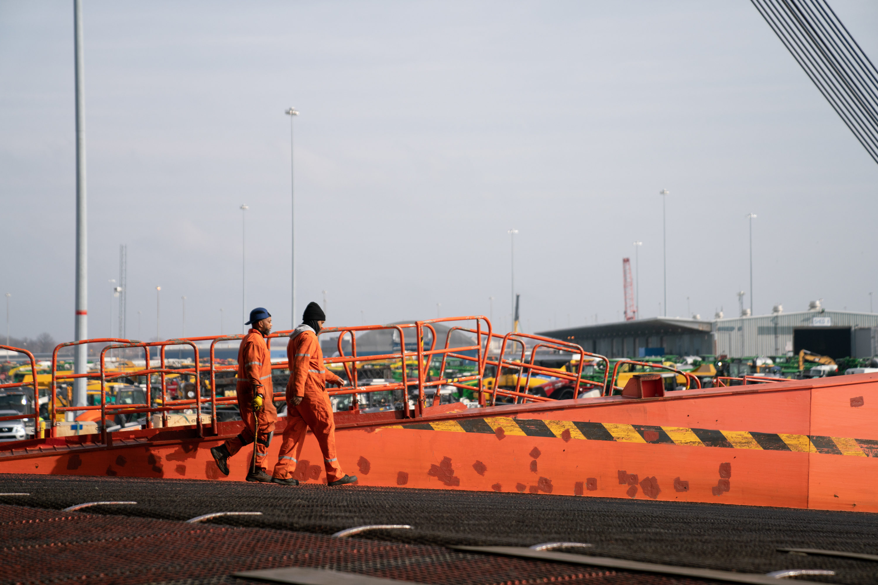 Workers at the Port of Baltimore walk down the stern ramp of a vessel. A group that normally welcomes crew members to the city is now acting as couriers, dropping off care packages to those stuck on board ships. (NPR)