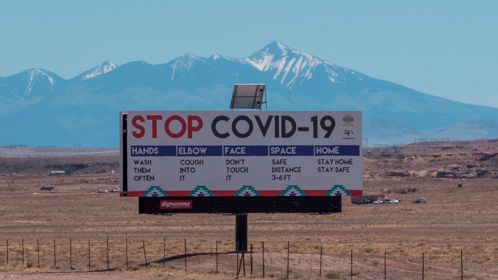 A sign warns against the Covid-19 virus near the Navajo town of Tuba City, Arizona. As the virus rages across the U.S., mitigation measures continue to be critical to save lives.