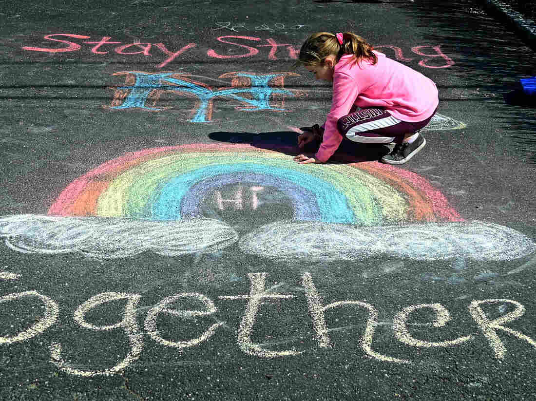 A girl makes chalk drawings on the driveway in West Islip, N.Y., in March 2020.