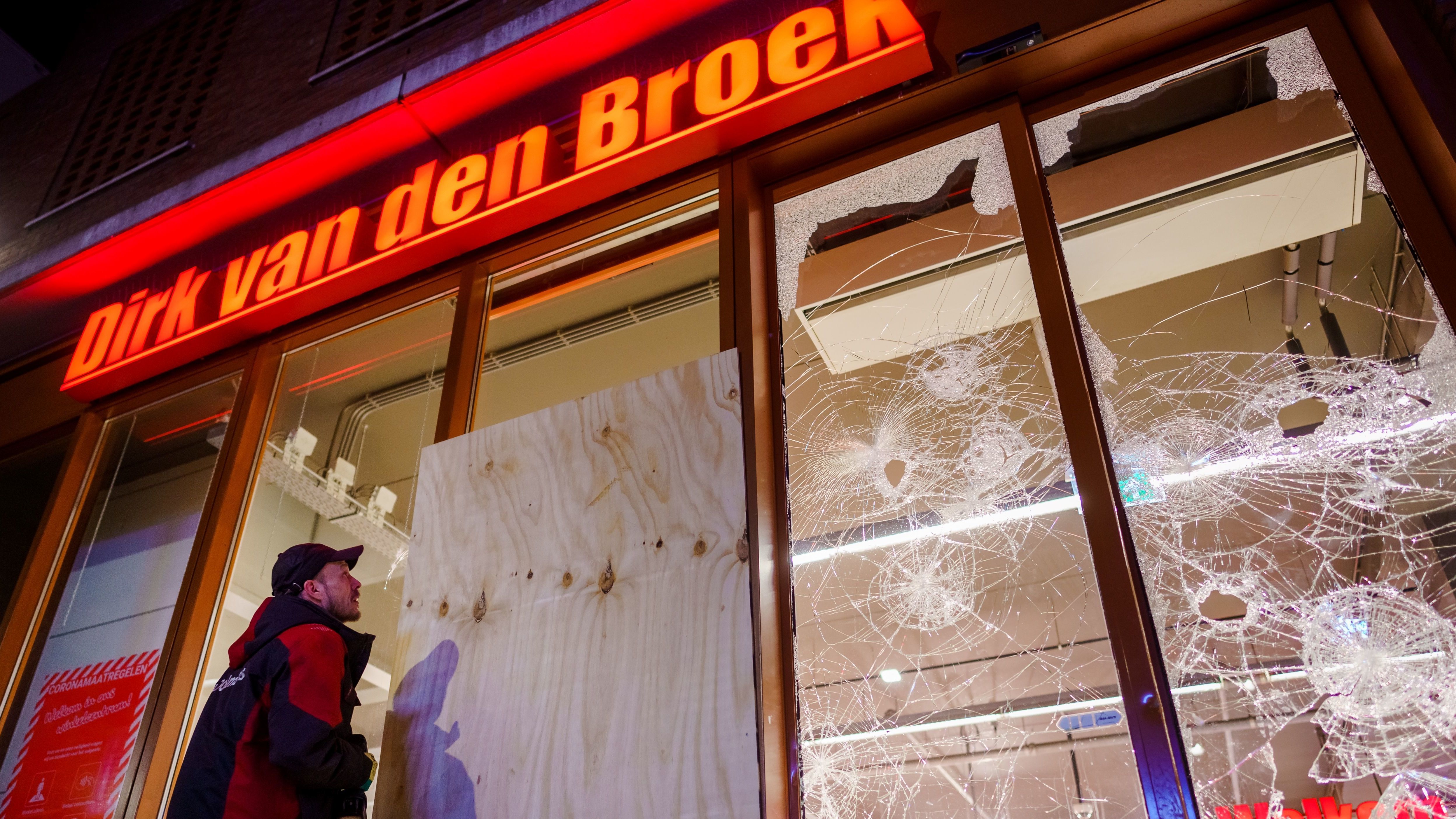 Protesters threw fireworks and rocks at police, damaged storefronts, and looted stores during demonstrations on Monday in the Netherlands.
