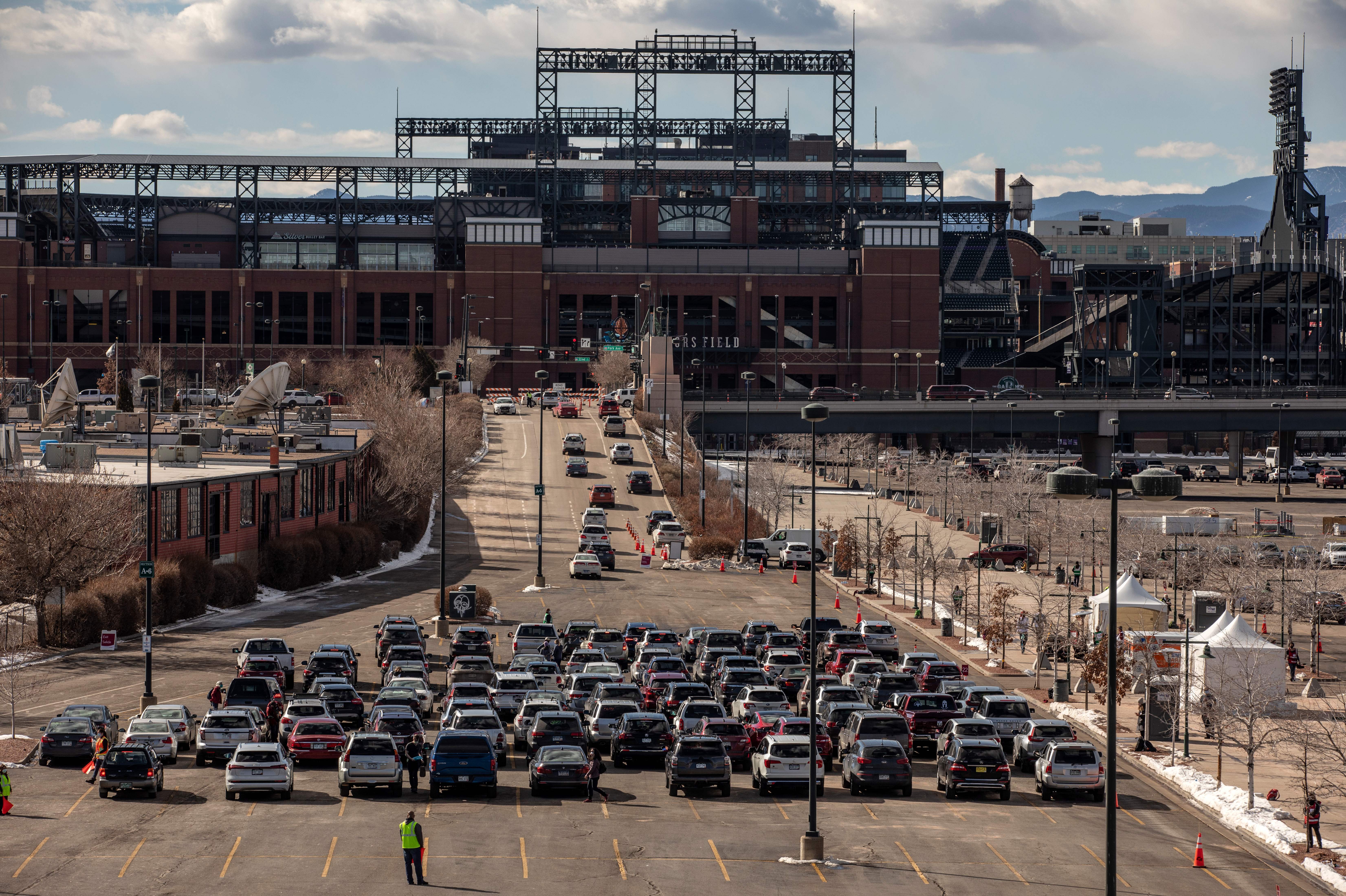 People line up for drive-through COVID-19 vaccination at Coors Field baseball stadium in Denver on Saturday. (AFP via Getty Images)
