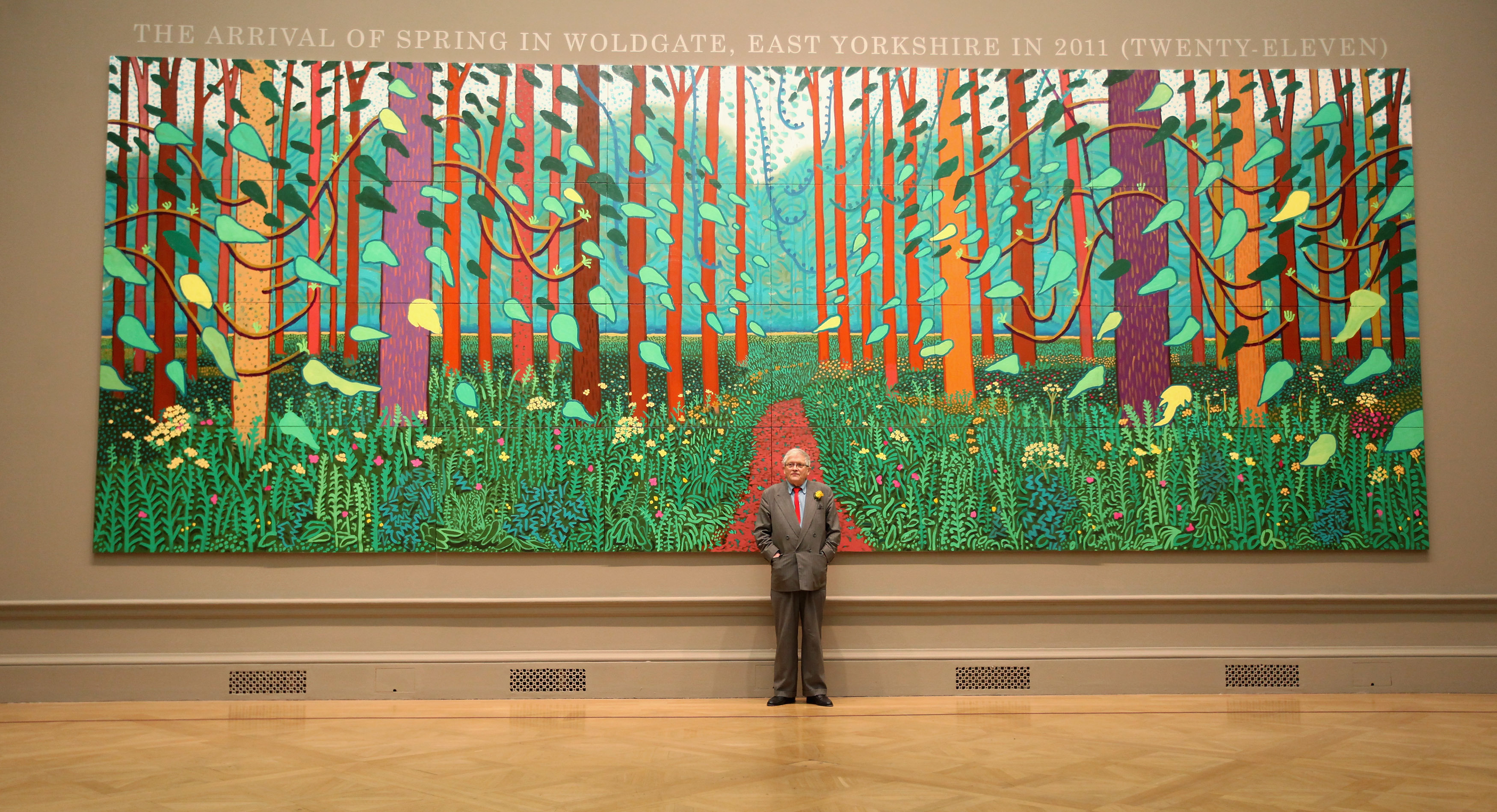 David Hockney, one of the most influential artists of the 20th century, dies at 88 1 Hockney poses in front of his painting The Arrival of Spring in Woldgate, East Yorkshire in 2011 at the Royal Academy of Arts on Jan. 16, 2012 in London.