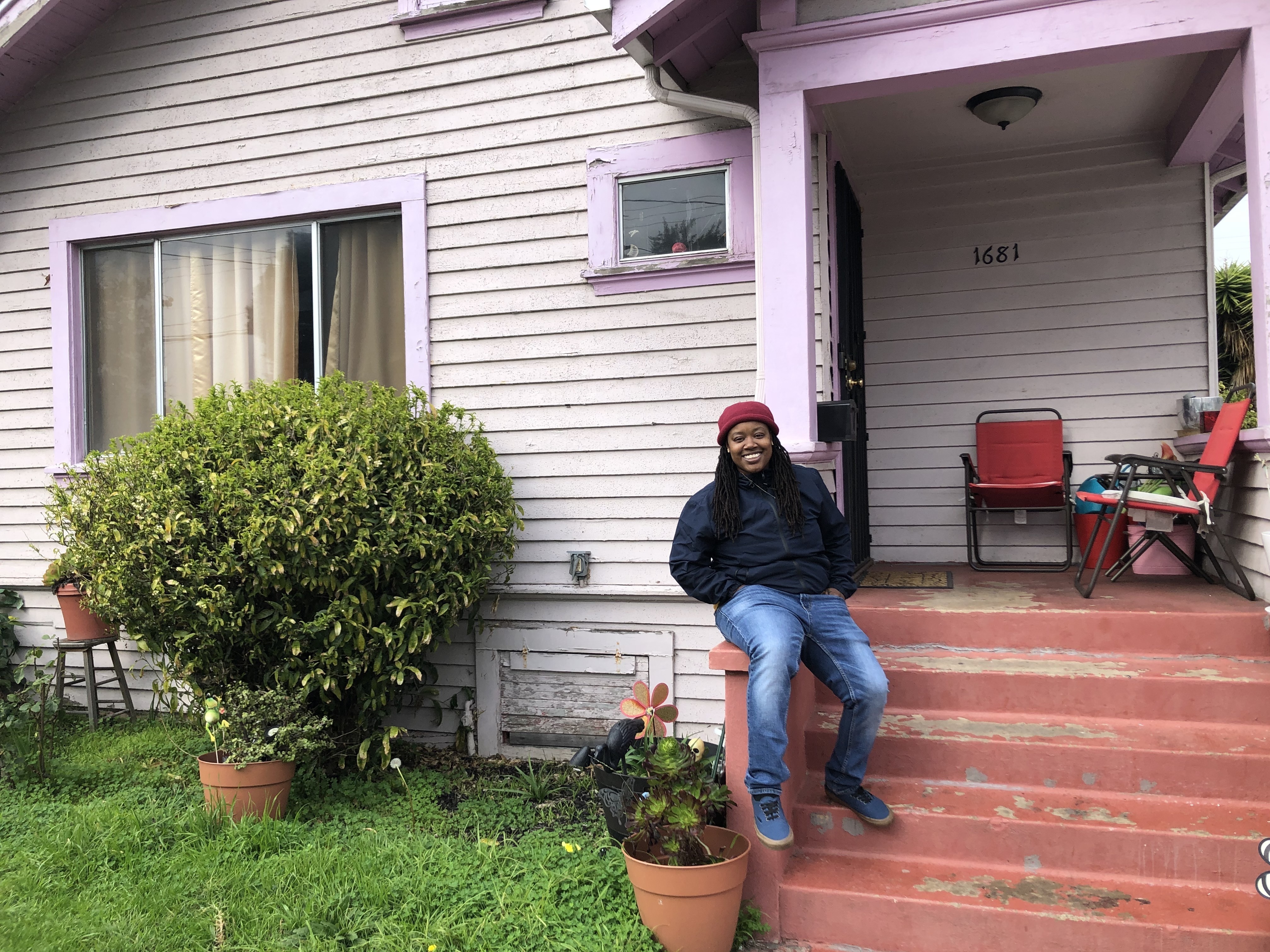 Marquita Price outside her grandmother's house in East Oakland. She worries that contaminated rising groundwater threatens the health of her family and their assets. (KQED)