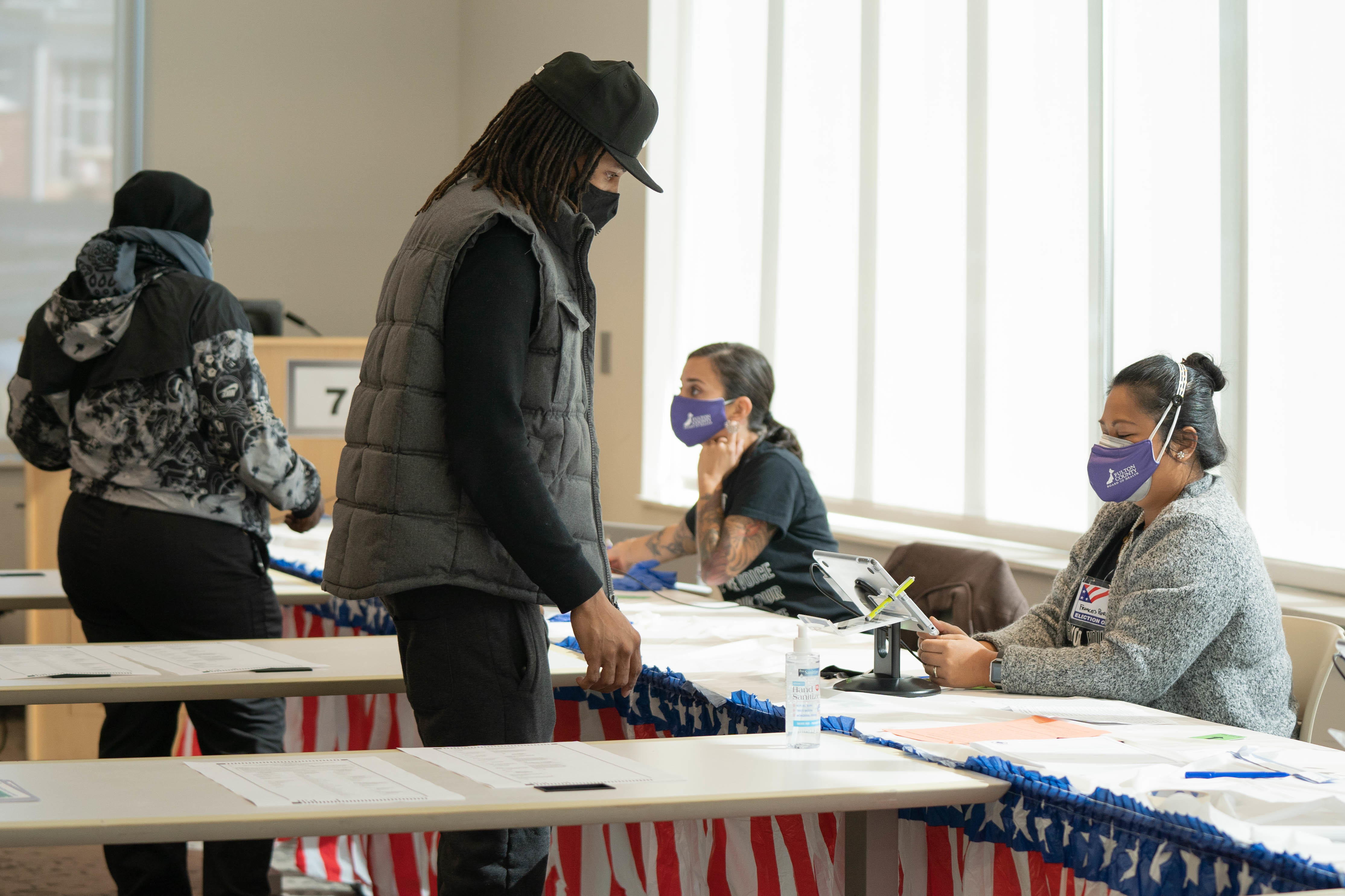 Poll workers help voters get ready to cast their ballots on Nov. 3 in Atlanta. State lawmakers are now considering legislation that could roll back some laws that made it easier for voters to cast ballots by mail. (Getty Images)