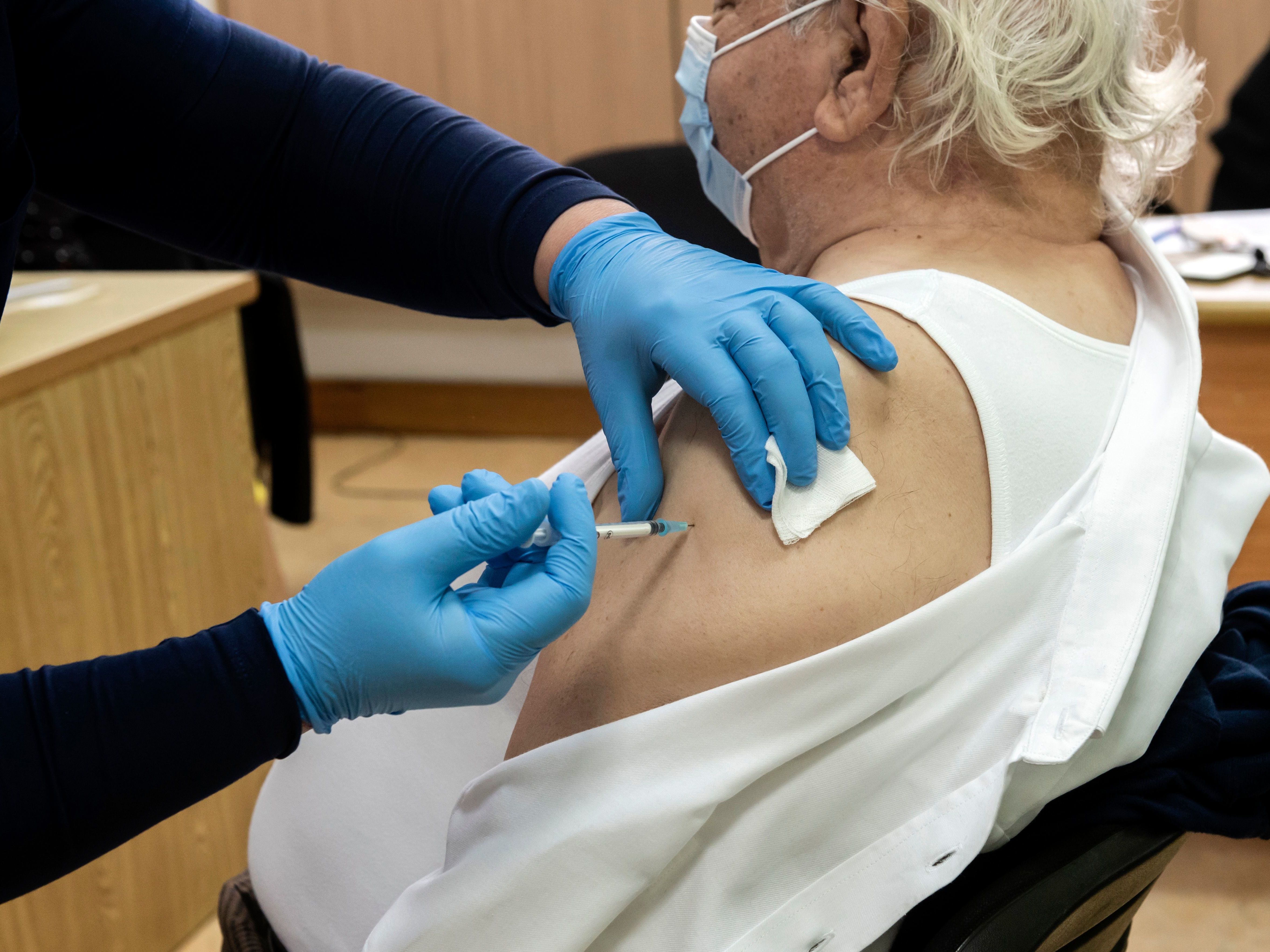 A healthcare worker administers a dose of the coronavirus vaccine to an elderly at a health center in the Cypriot coastal city of Limassol on February 8, 2021. (AFP via Getty Images)