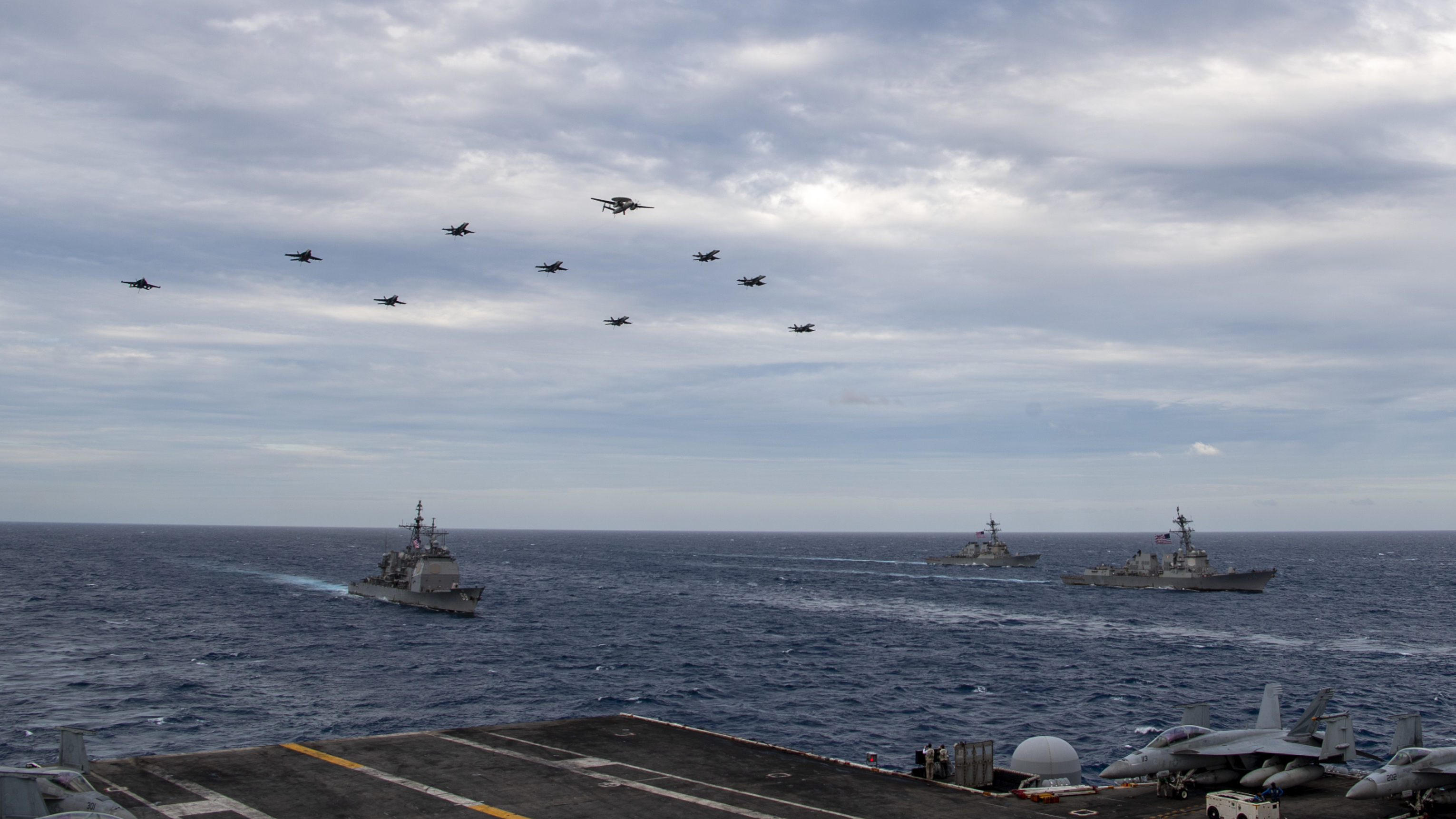 Aircraft assigned to Carrier Air Wing (CVW) 17 fly over the Theodore Roosevelt Carrier Strike Group and the Nimitz Carrier Strike Group in the South China Sea on Tuesday.