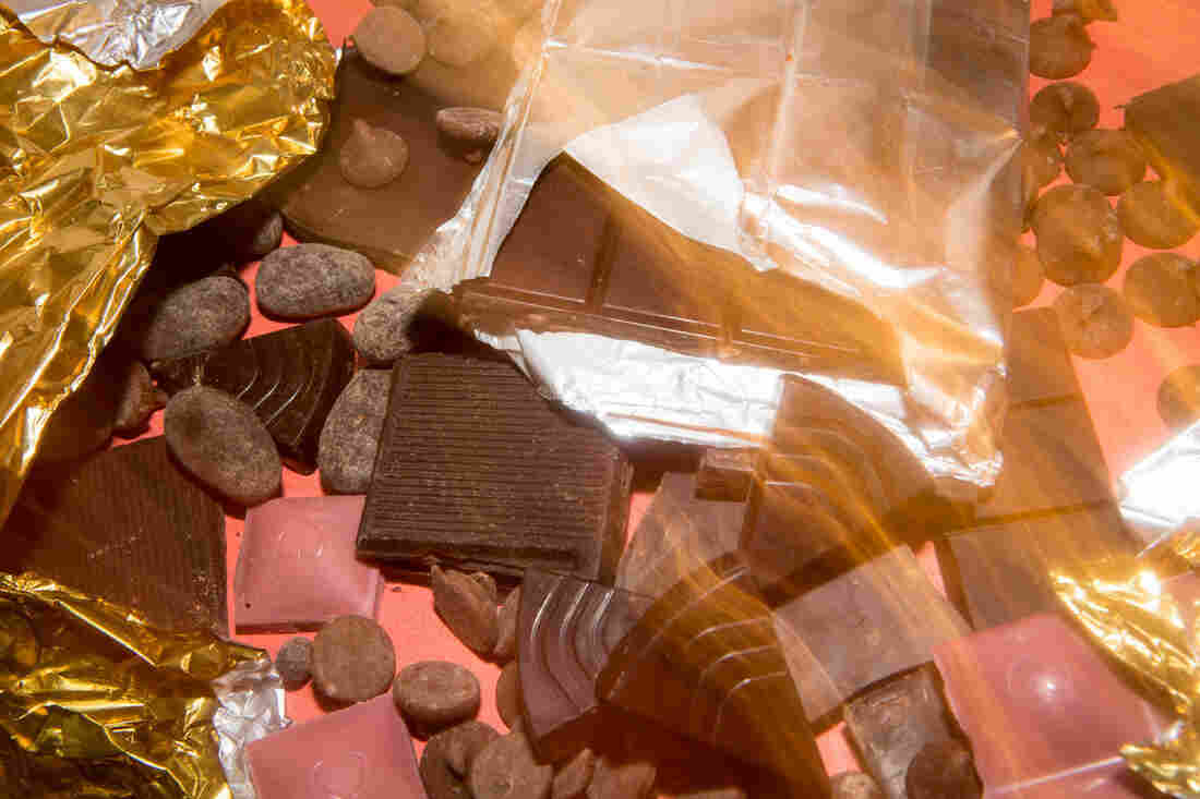 A long exposure photo of a pile of chocolate on a red background.