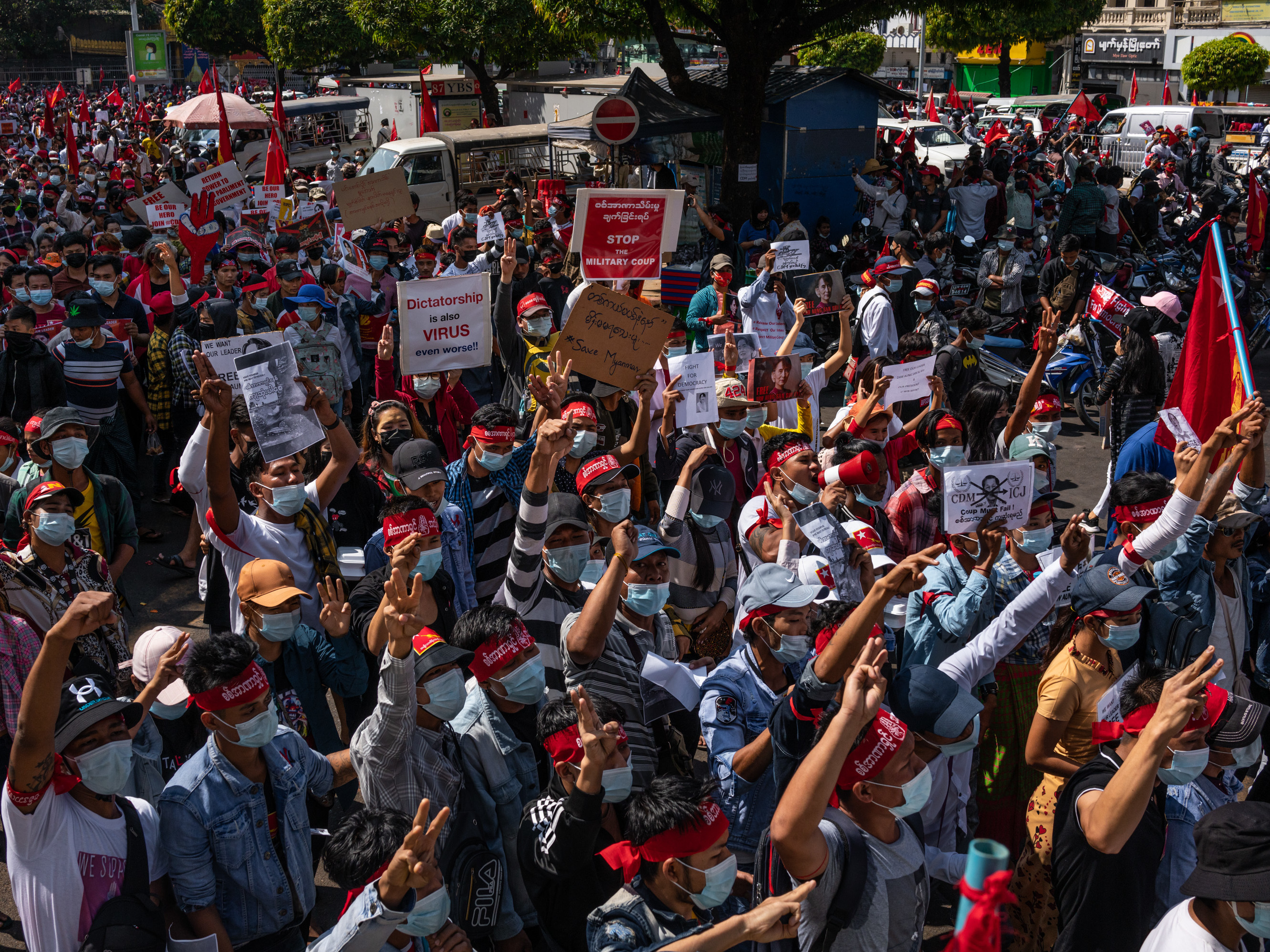 Protesters hold placards and shout slogans on Saturday in Yangon, Myanmar. Myanmar declared martial law in parts of the country, including its two largest cities, as protests continued to draw people to the streets after the military staged a coup. (Getty Images)