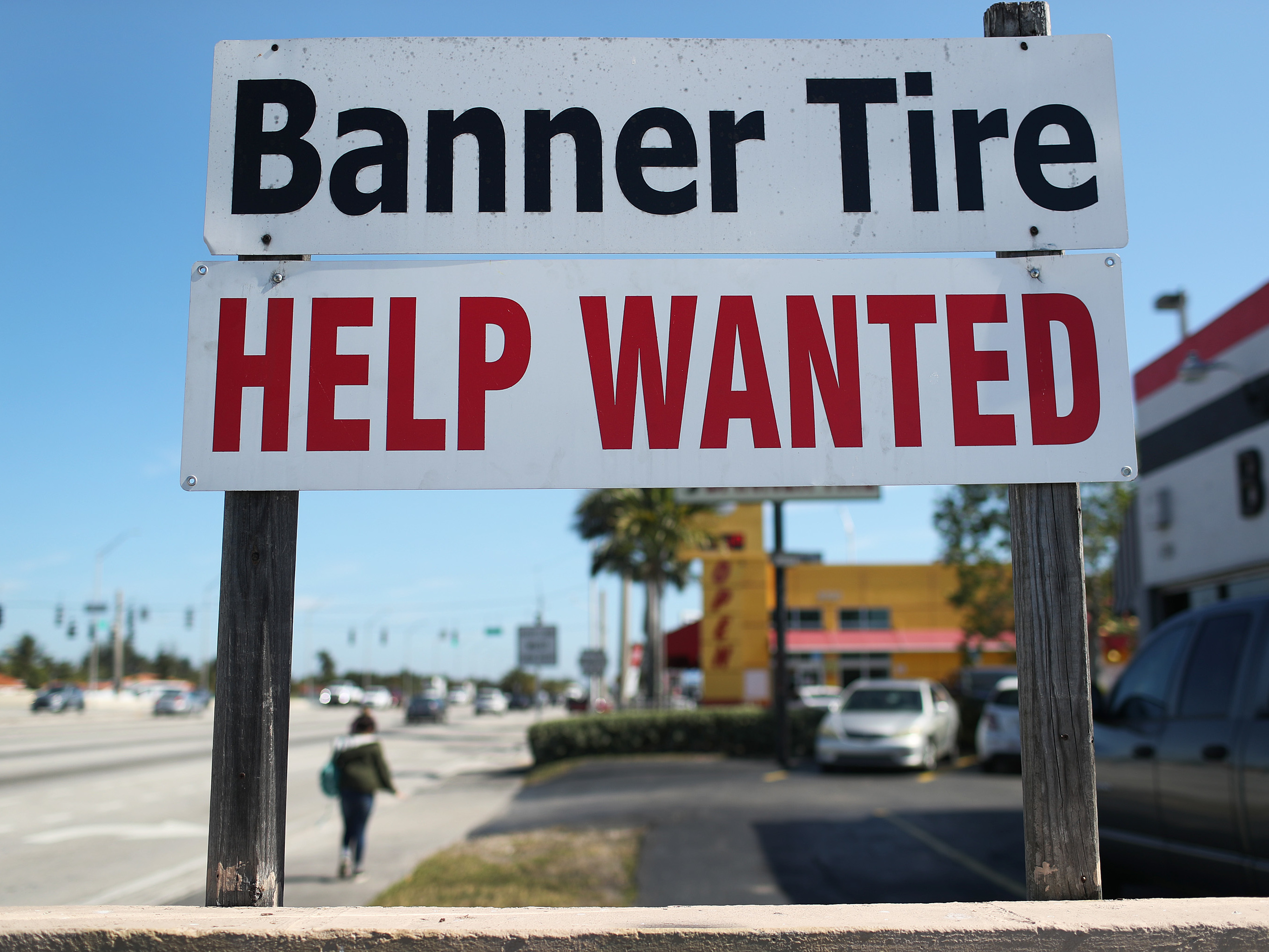 A &quot;Help Wanted&quot; sign is posted in front of a business on Feb. 4 in Miami. Although millions are unemployed, some businesses that require being on-site are struggling to find workers. (Getty Images)