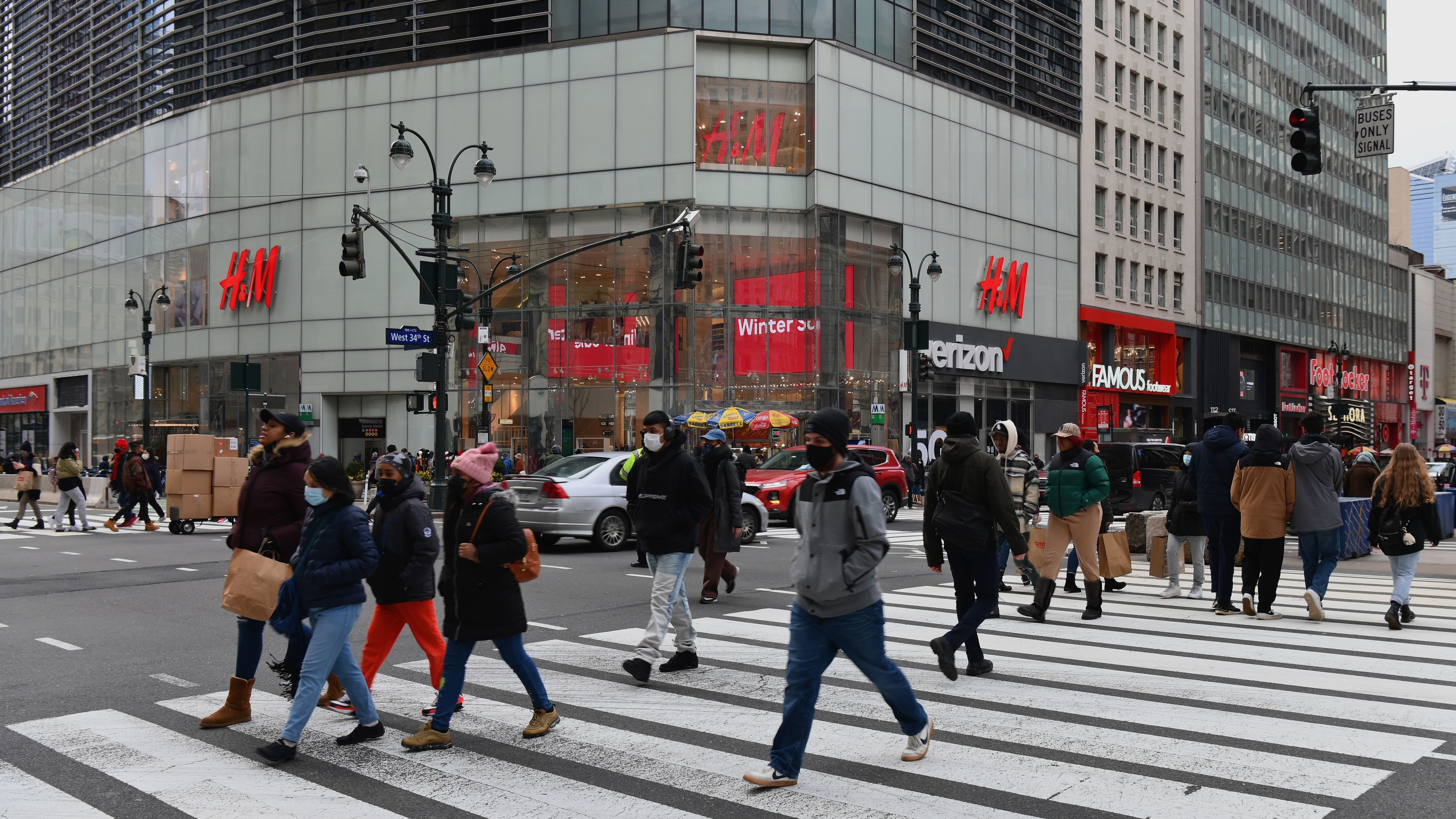 People walk in front of stores in New York