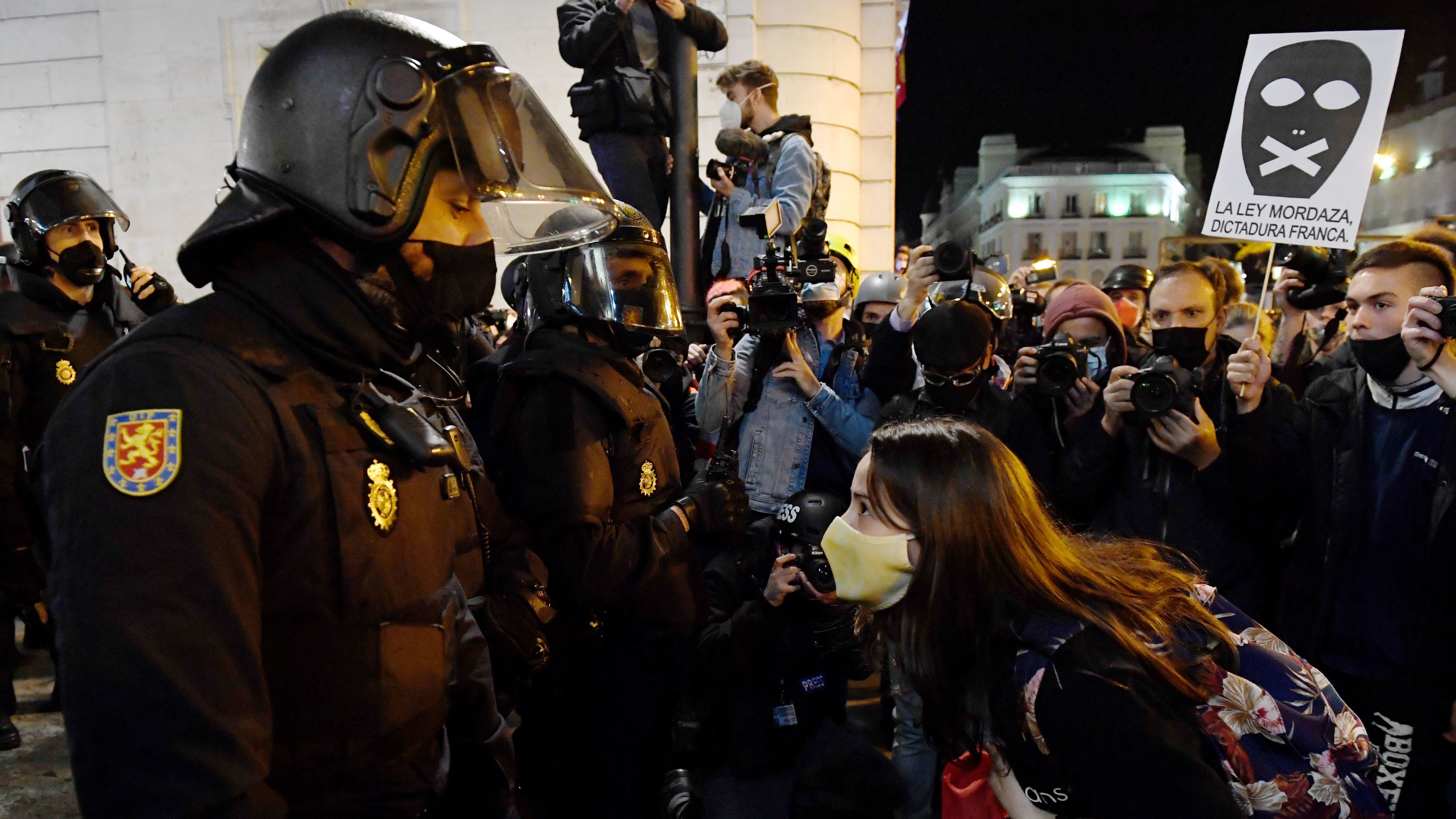 A woman talks to police during a demonstration against the imprisonment of Spanish rapper Pablo Hasél in Madrid. Clashes between police and protestors have gone on for three days and have led to dozens of arrests and injuries.