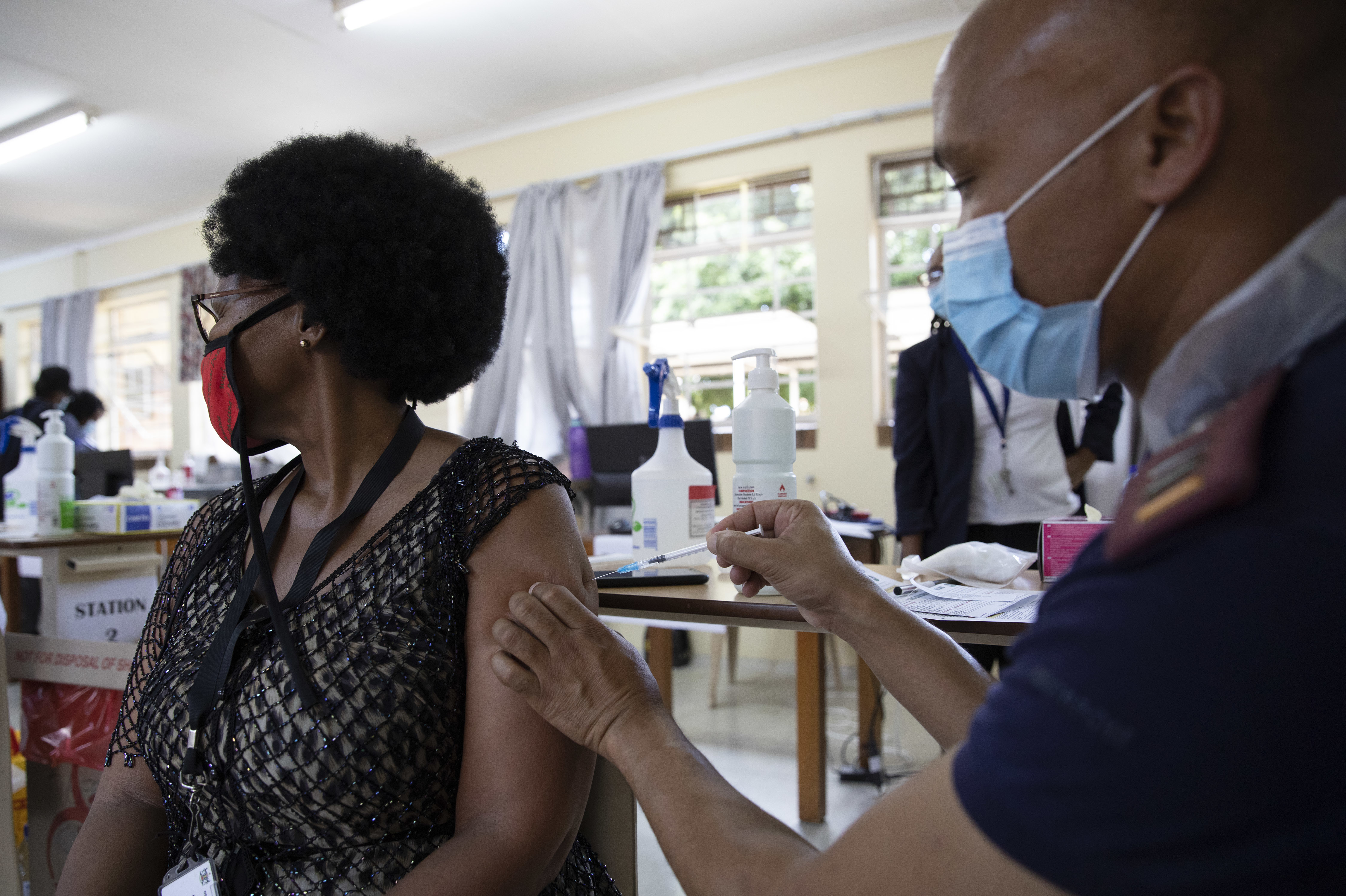 A health care worker looks away as she's immunized with Johnson & Johnson's COVID-19 vaccine at Klerksdorp Hospital in Klerksdorp, South Africa, on Feb. 18. (AFP via Getty Images)
