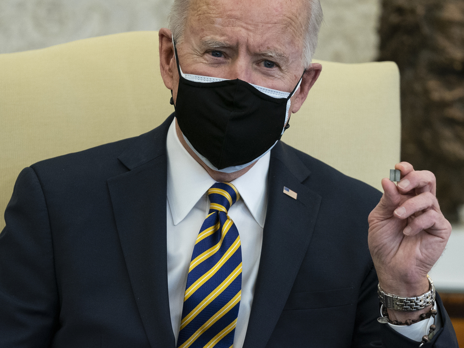 President Biden holds up a semiconductor chip during a meeting with lawmakers to discuss U.S. supply chain shortages. (Evan Vucci/AP)