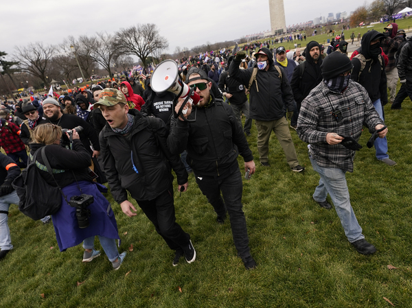 Prosecutors say Ethan Nordean, seen with a bullhorn, led members of the far-right group the Proud Boys in the Jan. 6 riot. He faces federal charges, but will be released from custody while he awaits trial.