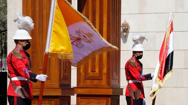 Iraqi honour guards hold the flags of Iraq and the Vatican at the presidential palace in Baghdad ahead of the arrival of Pope Francis after he landed at the capital