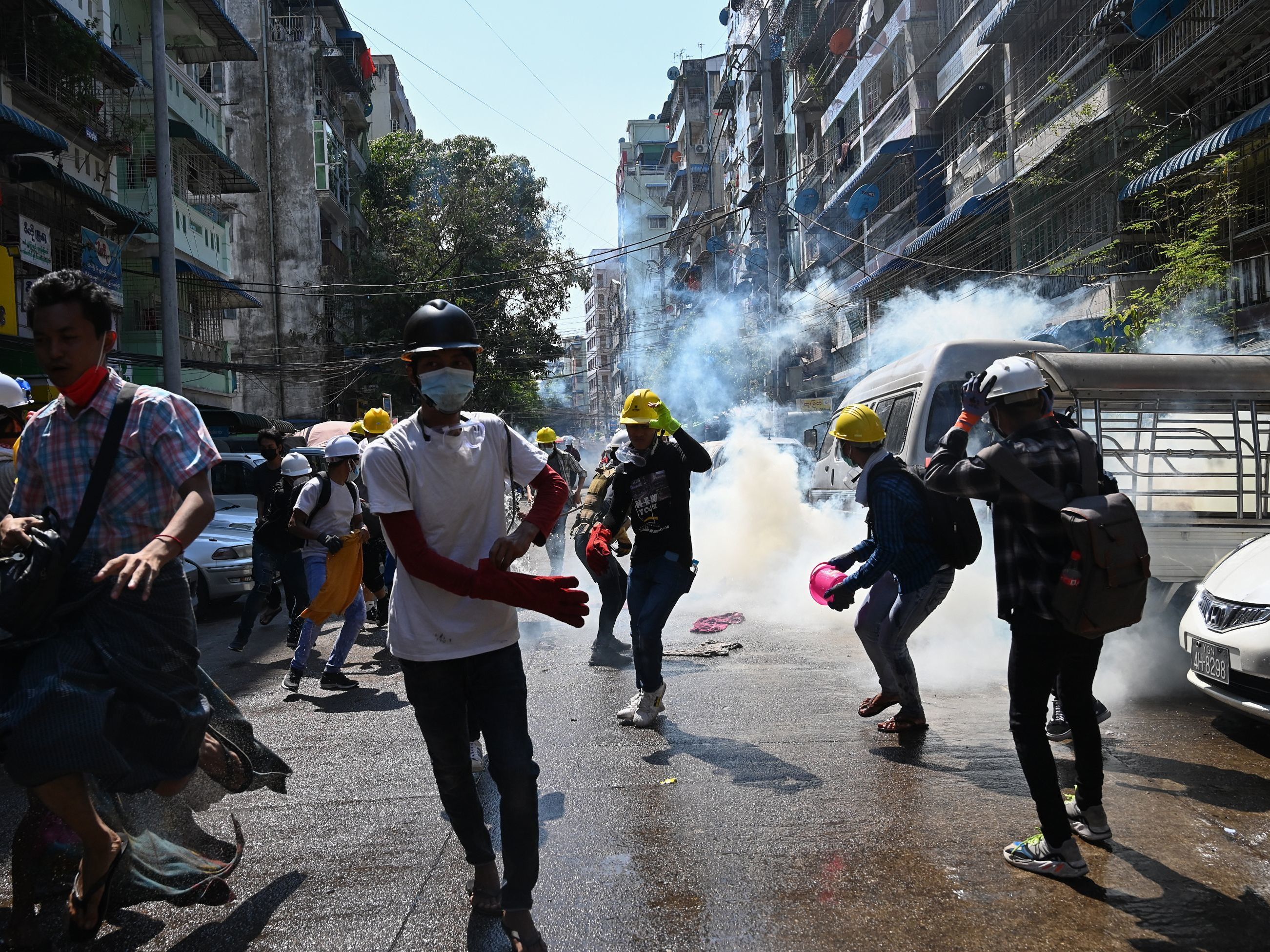 Protesters in Yangon run from police Sunday after they fire tear gas during a demonstration against the military coup. (AFP via Getty Images)