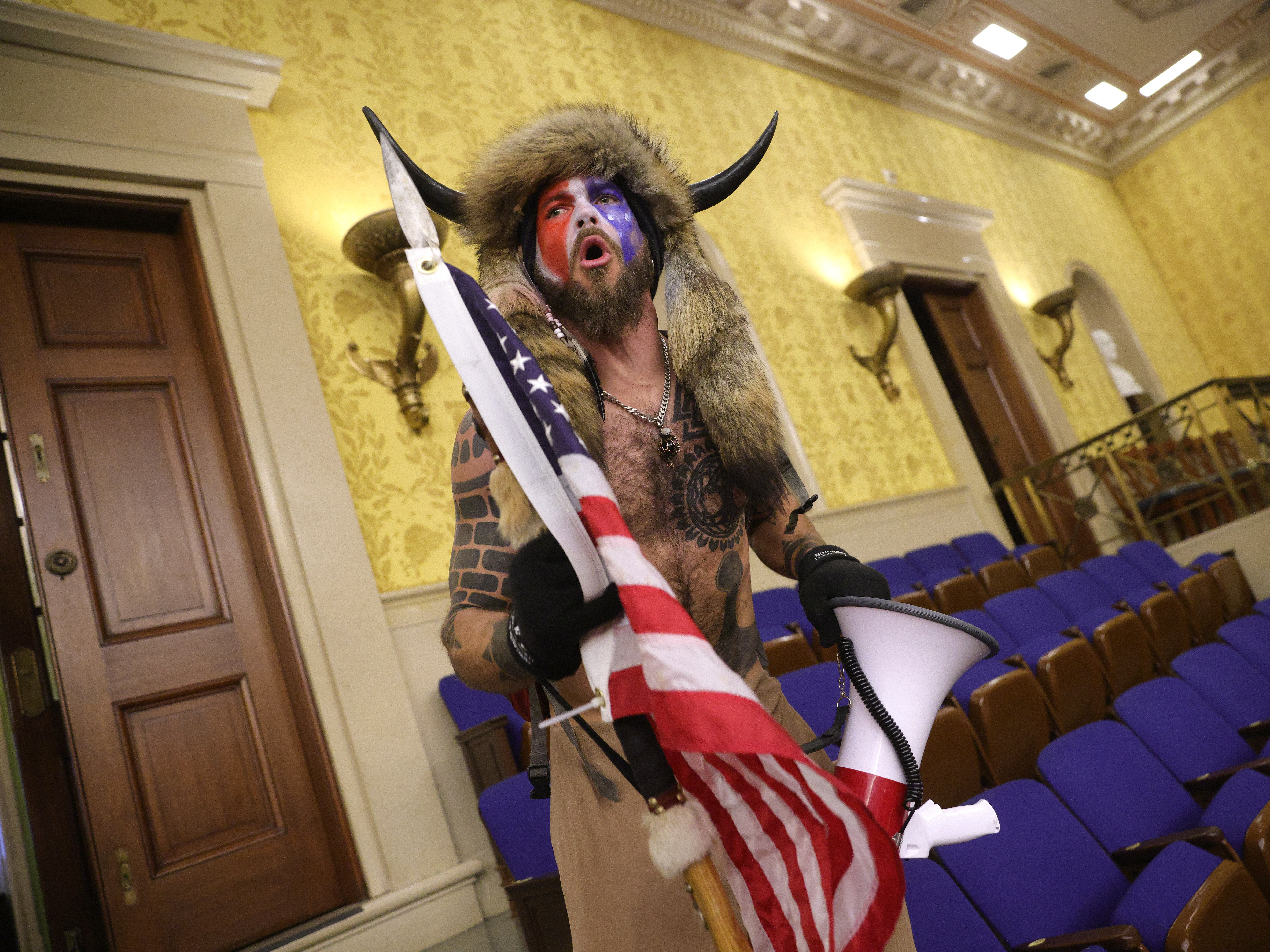 Jacob Chansley, photographed during the Jan. 6 U.S. Capitol insurrection, screams &quot;Freedom&quot; inside the Senate chamber following the breach of a mob during a joint session of Congress. (Getty Images)