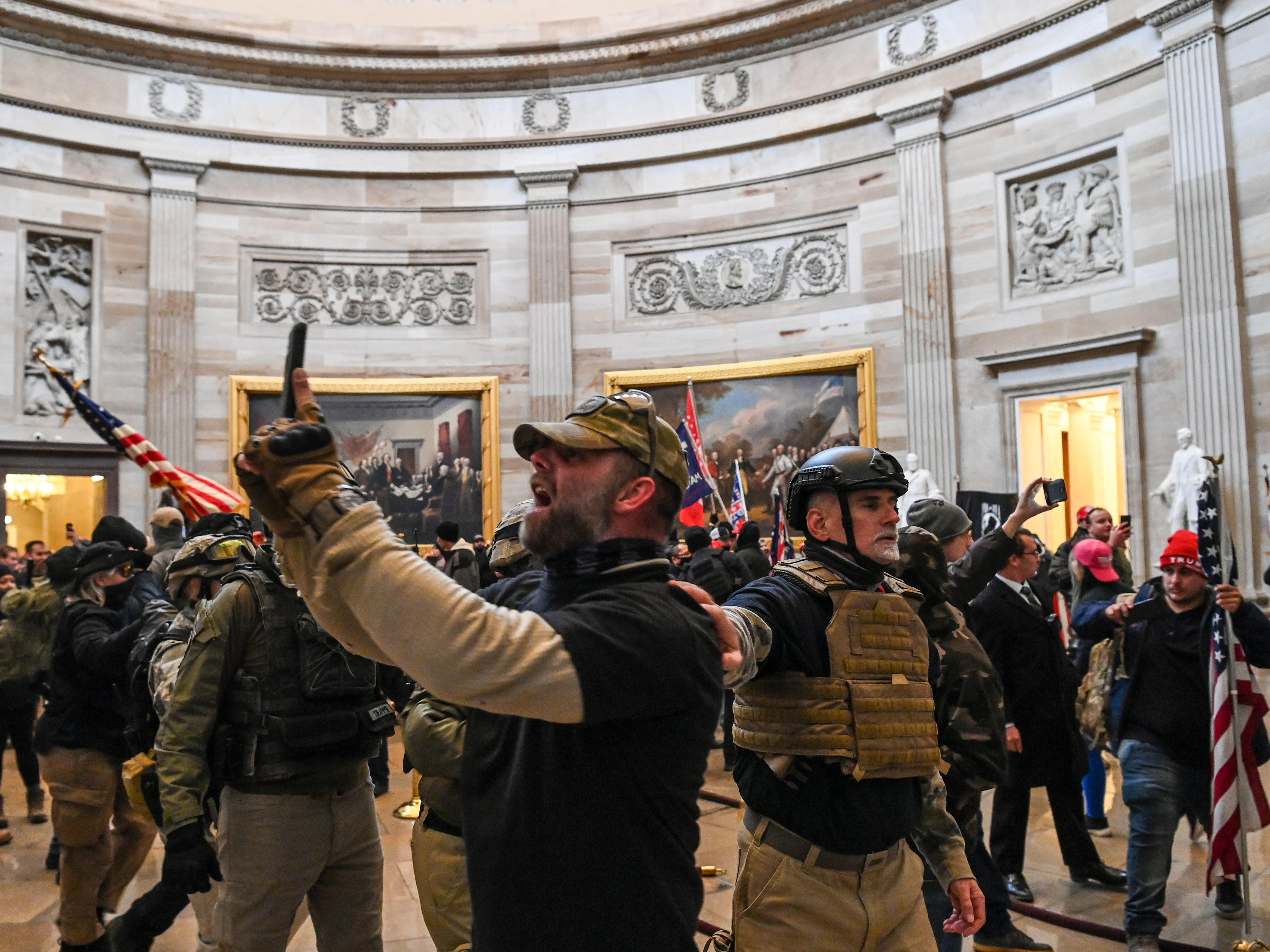 Kenneth Harrelson, identified in an FBI affidavit as the man at center holding a phone in the Capitol Rotunda, is charged with obstructing an official proceeding, destruction of government property, entering a restricted building and conspiracy. (AFP via Getty Images)