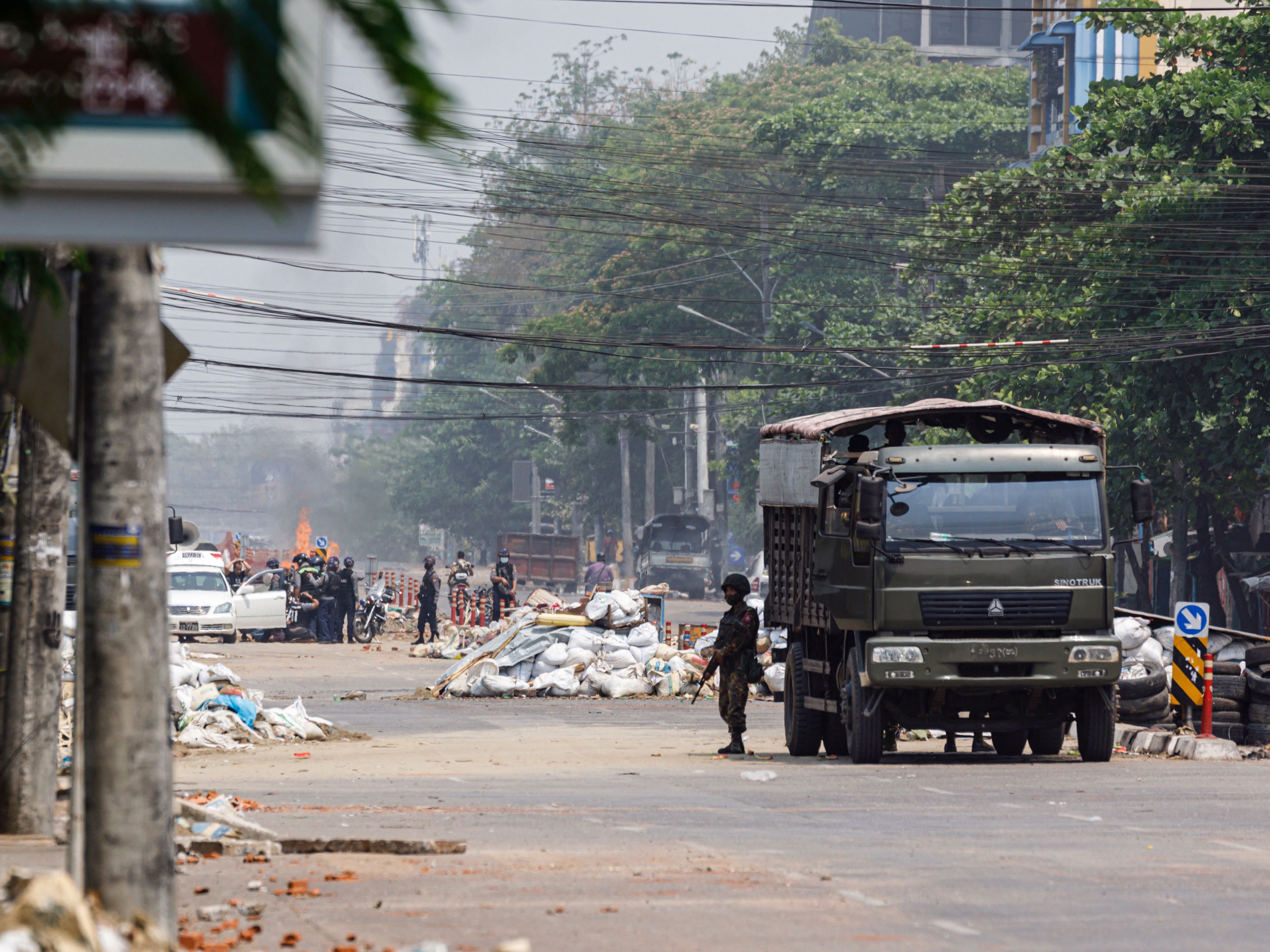 Security forces stand guard on a road as people are arrested, next to dismantled barricades that were set up by protesters demonstrating against the military coup, in Yangon, Myanmar, on Friday. (AFP via Getty Images)