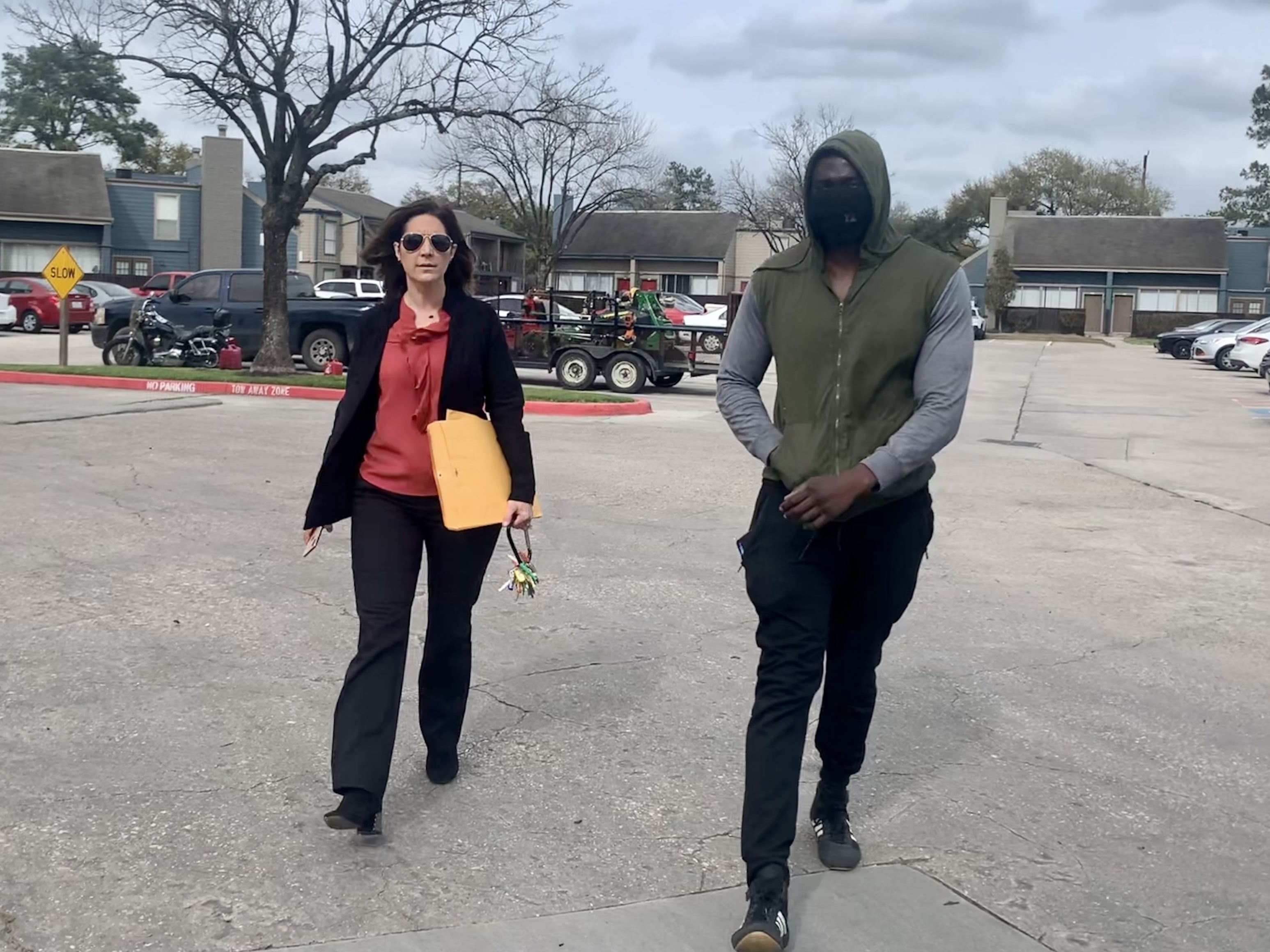 Landlord Stephanie Graves walks to the main office at one of her properties in Houston with a resident. She's going door to door offering to help residents apply for rental assistance money approved by Congress that's just starting to flow to landlords and tenants. (Stephanie Graves)