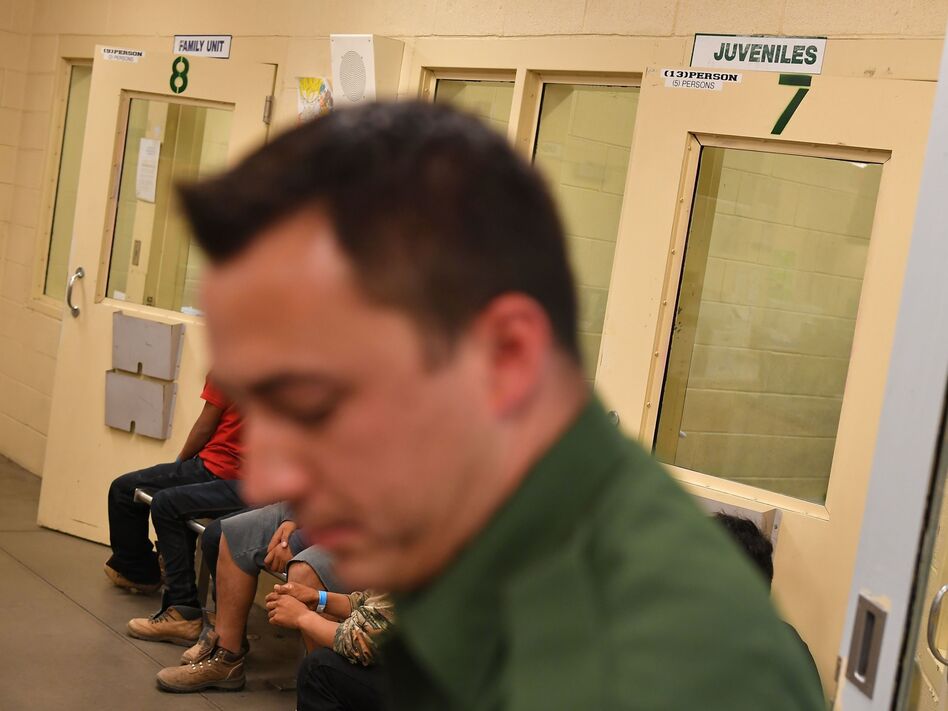 In this file photo, young migrants, whose faces cannot be shown, sit inside a U.S. Customs and Border Protection Facility in Tucson, Arizona. (Mandel Ngan/AFP via Getty Images)