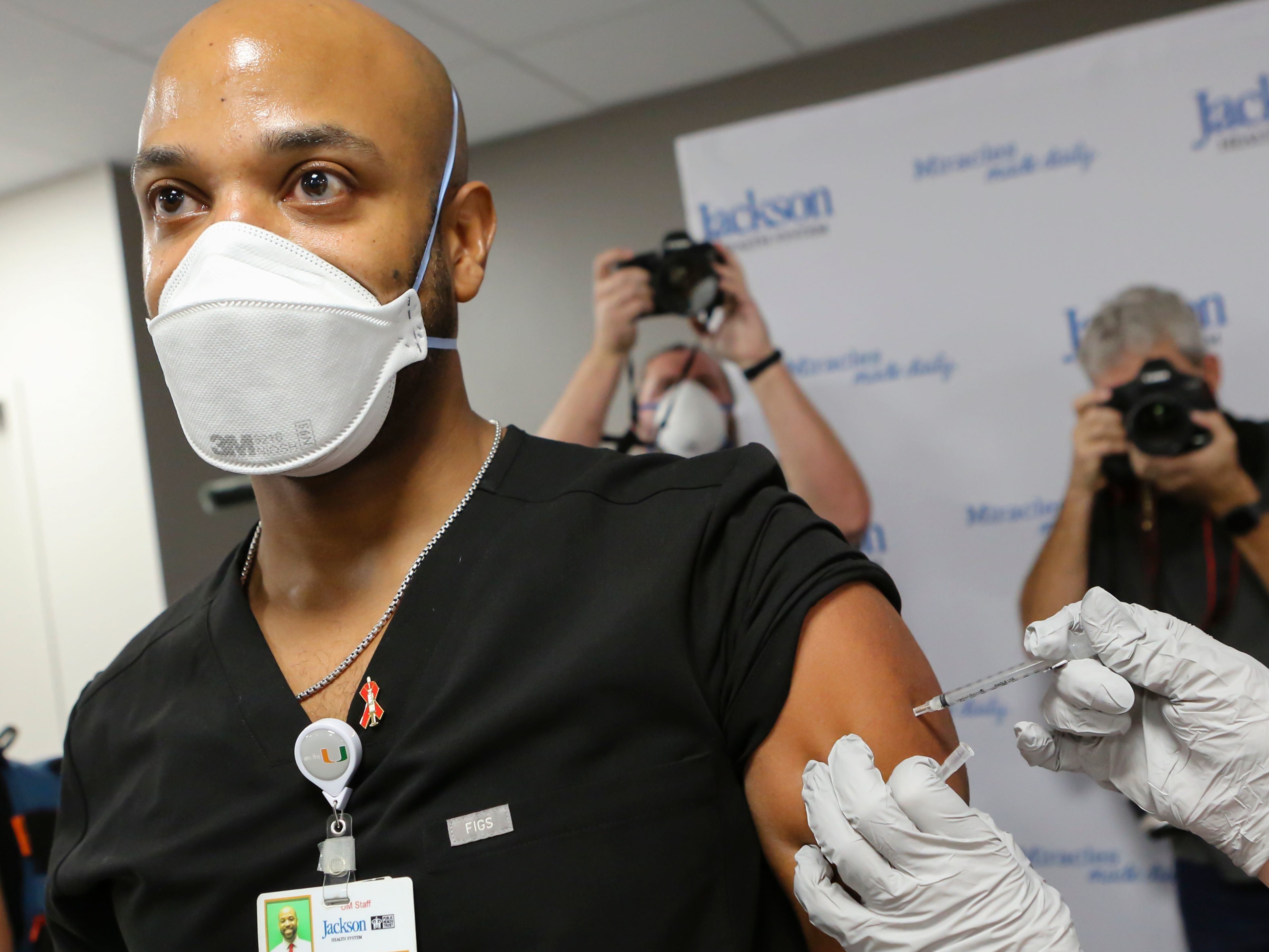 Dr. Hansel Tookes made sure his first dose of Pfizer's COVID-19 vaccine at Jackson Memorial Hospital in Miami on Dec. 15. was televised, as a way to combat hesitancy. (AFP via Getty Images)