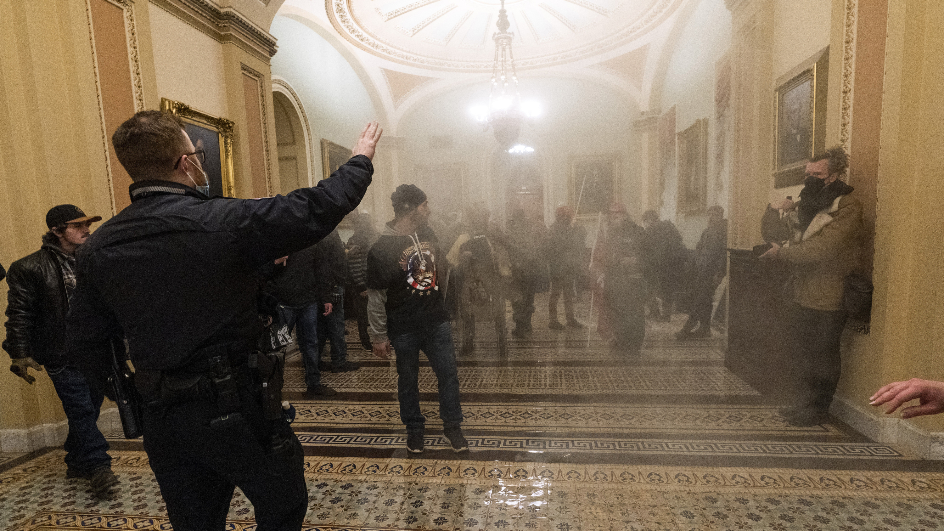 Smoke fills the walkway outside the Senate Chamber as rioters are confronted by U.S. Capitol Police officers inside the Capitol in Washington on Jan. 6.