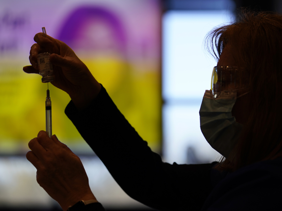 A county health worker fills a syringe with the Moderna COVID-19 vaccine in West Chester, Pa., in late December. Rutgers University will require students enrolling for the fall semester to show they have received a COVID-19 vaccine. (Matt Slocum/AP)