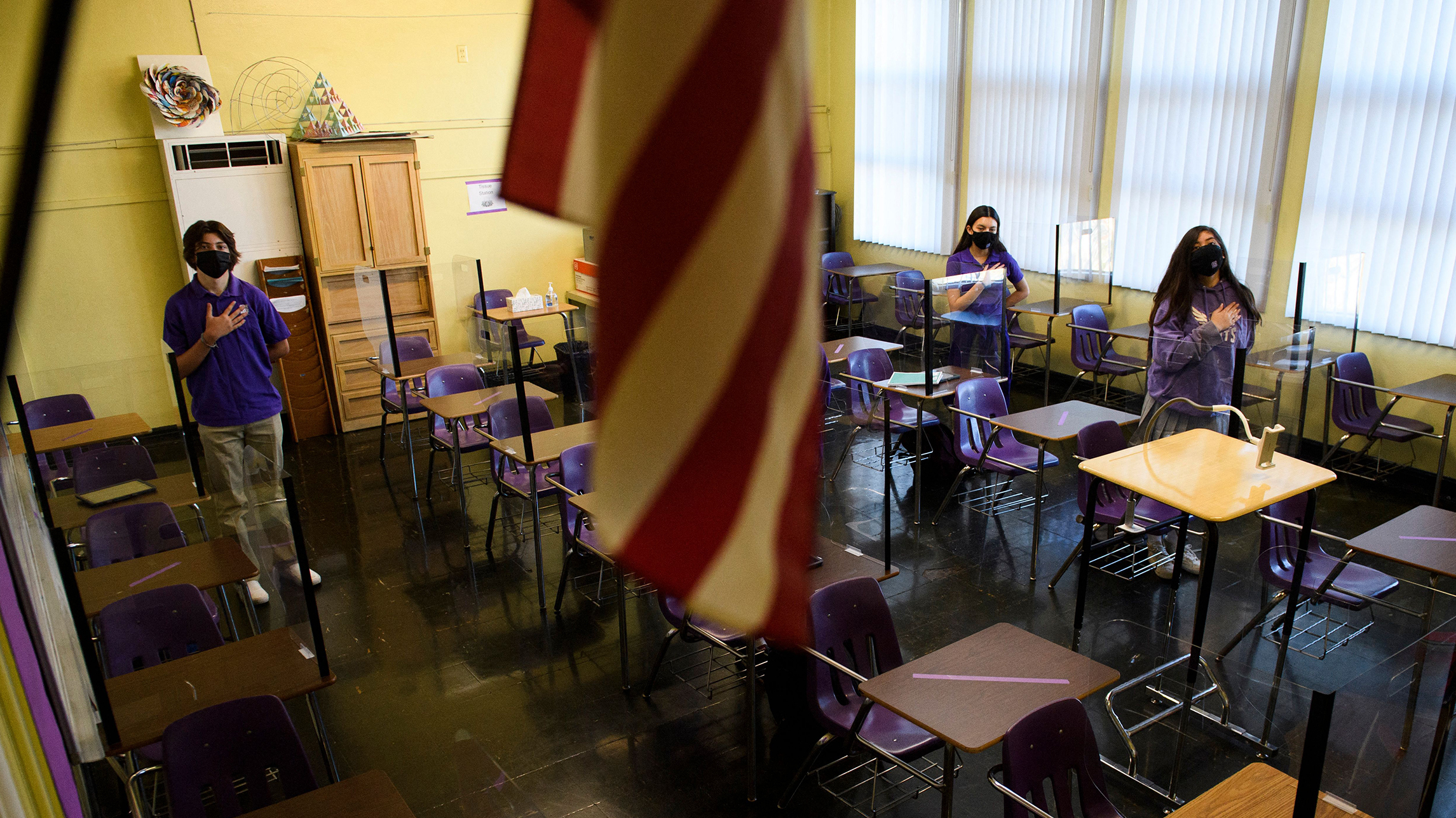 Students stand for the Pledge of Allegiance as they return to in-person learning at St. Anthony Catholic High Schoo in California on March 24, 2021. Masks and physical distancing are proving to have some major public health benefits, keeping people from getting all kinds of illnesses, not just COVID-19. But it