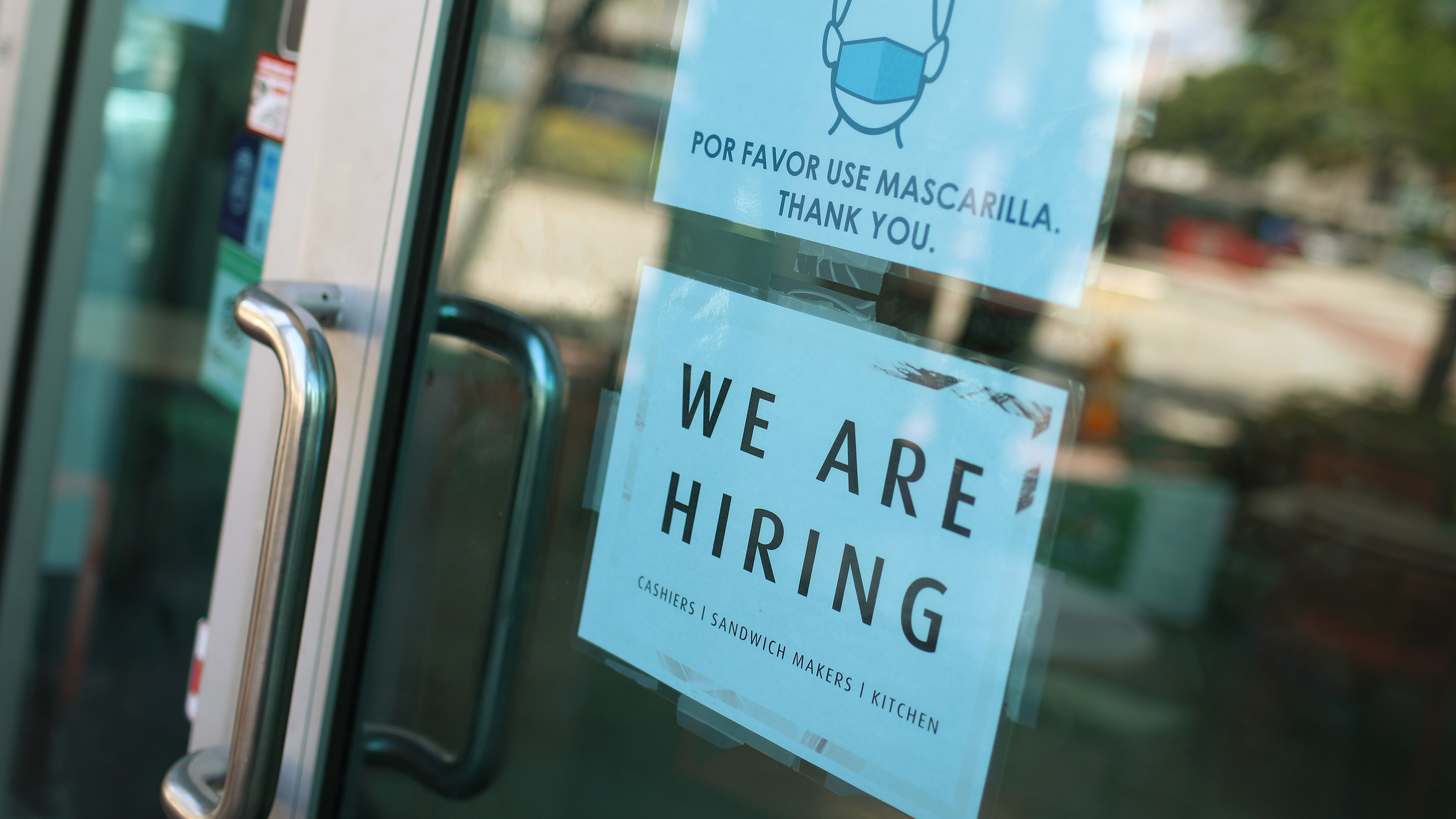 A store in Miami displays a "We are hiring" sign on March 5. U.S. employers added 916,000 jobs in March, the biggest number since August, amid an improving pandemic outlook and trillions of dollars in stimulus passed by Congress.